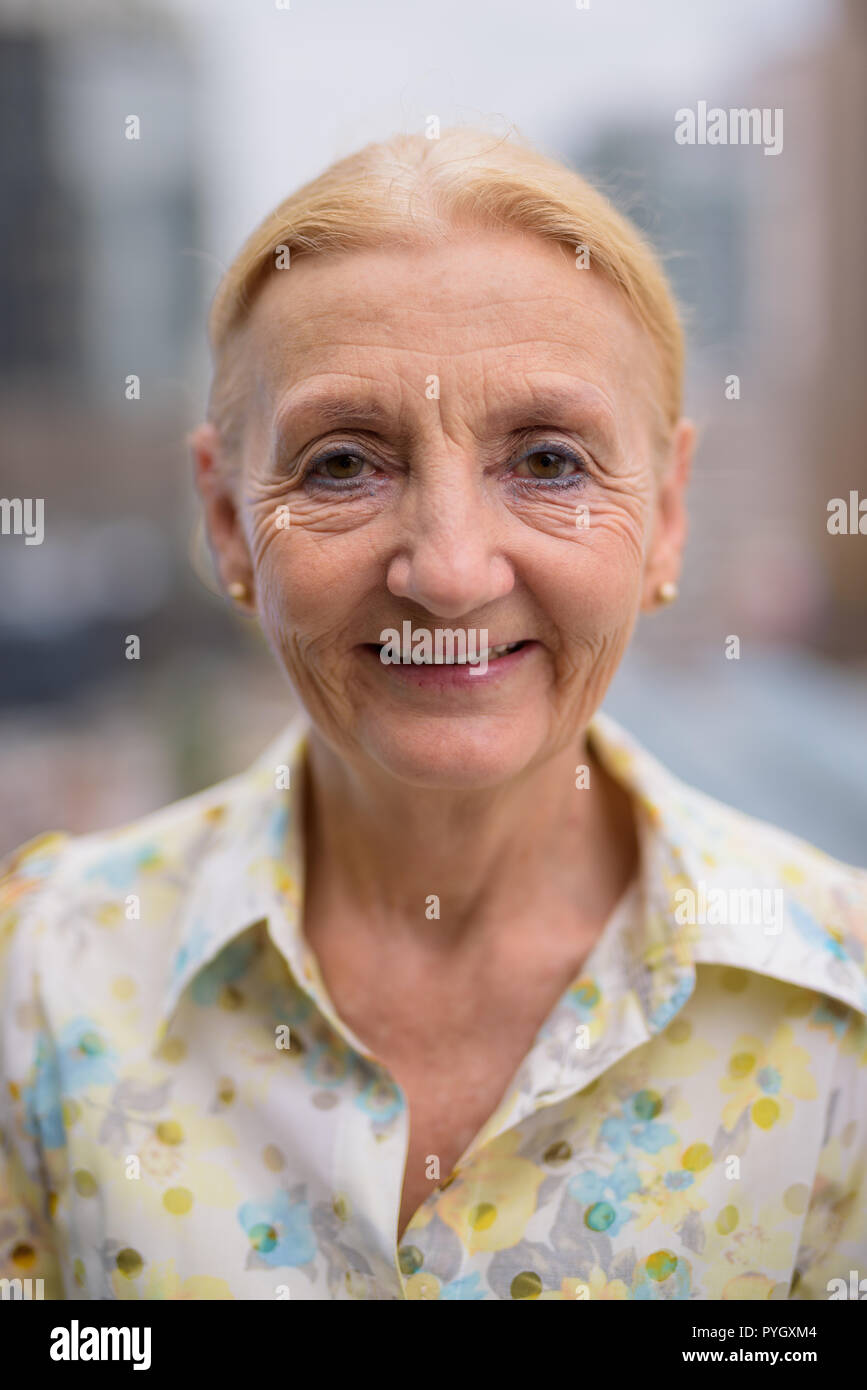 Gerne schöne ältere Frau lächelnd im Freien in der Stadt Stockfoto