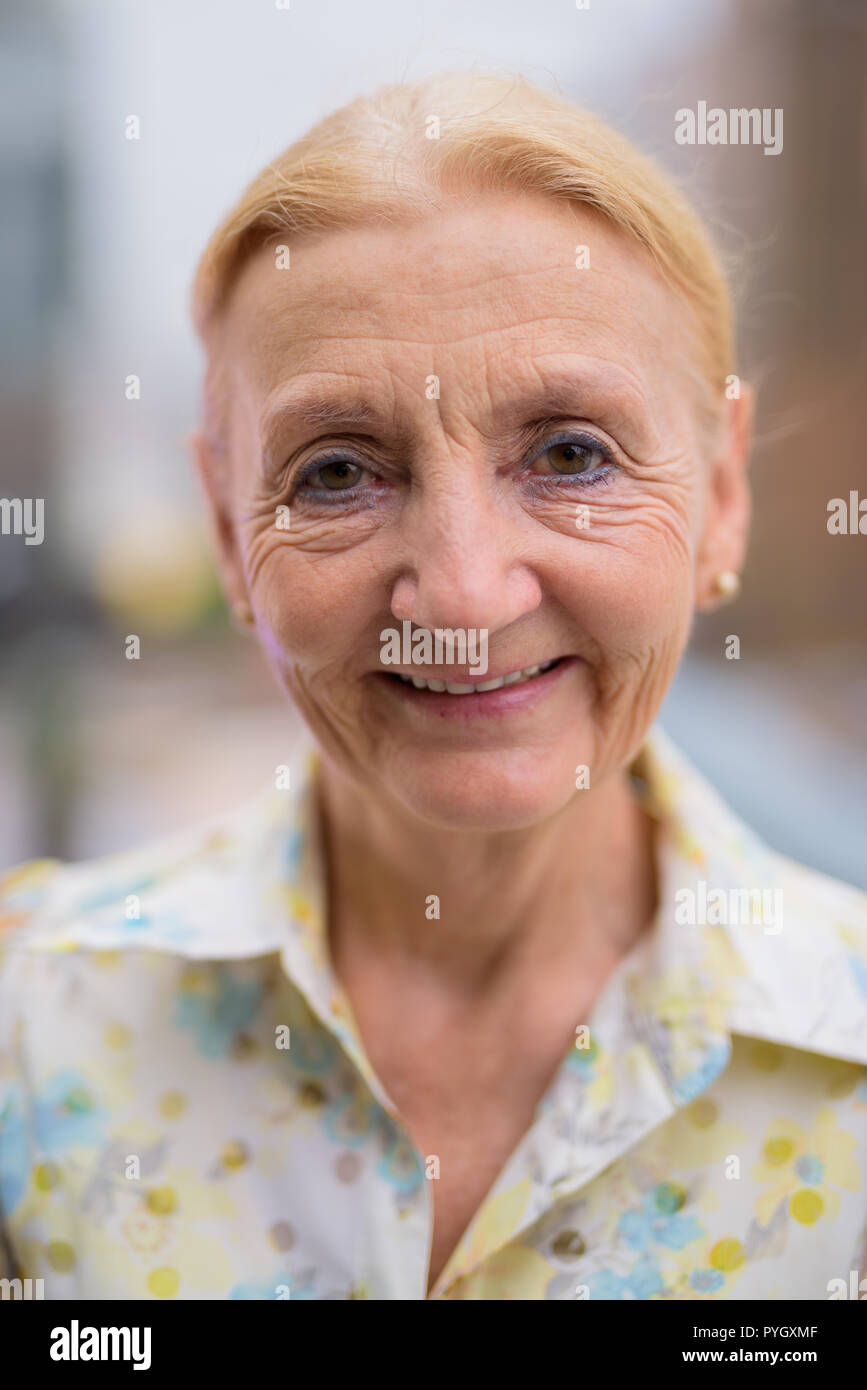 Gerne schöne ältere Frau lächelnd im Freien in der Stadt Stockfoto