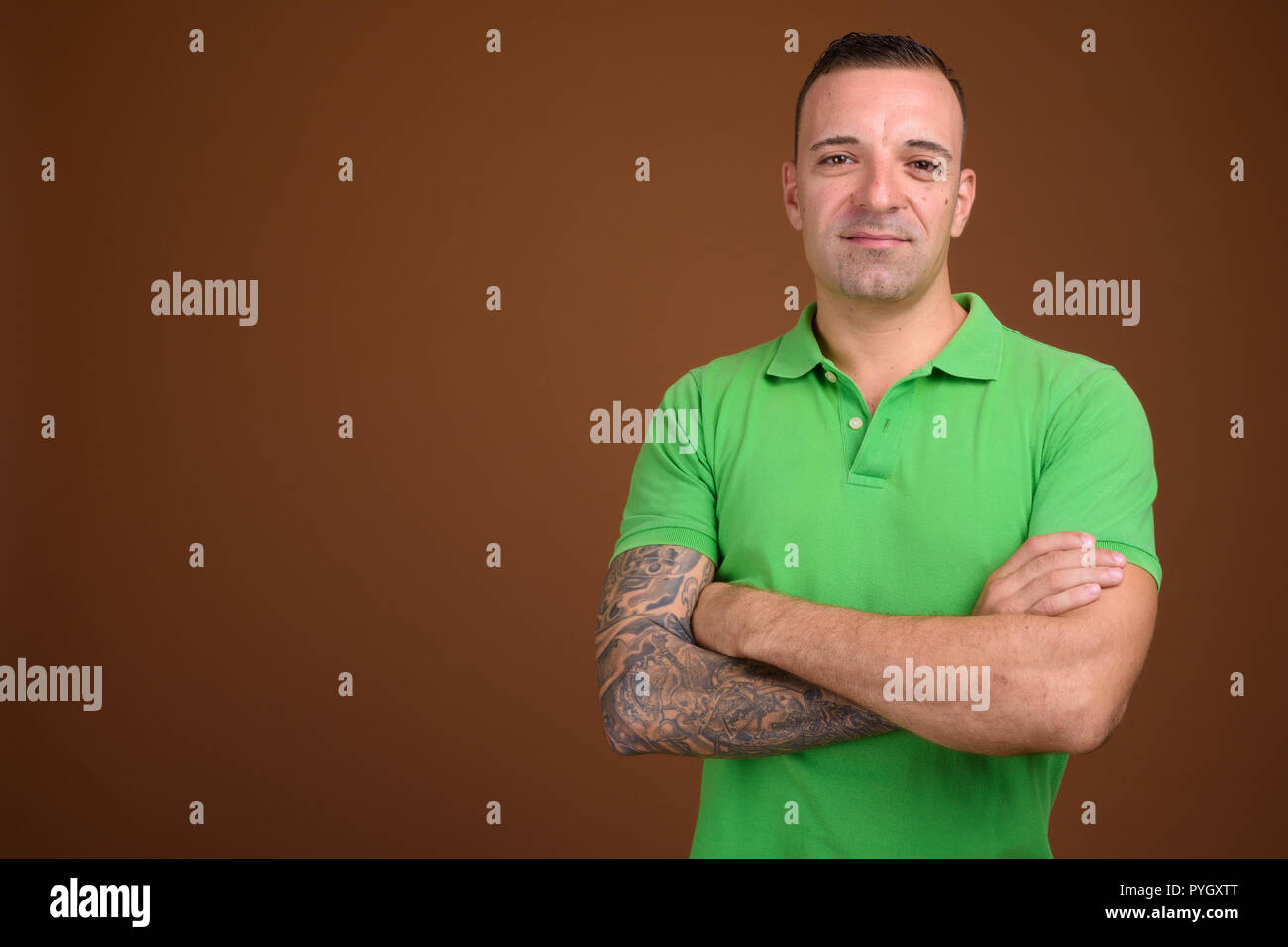 Mann, grünes T-Shirt gegen die braunen Hintergrund Stockfoto