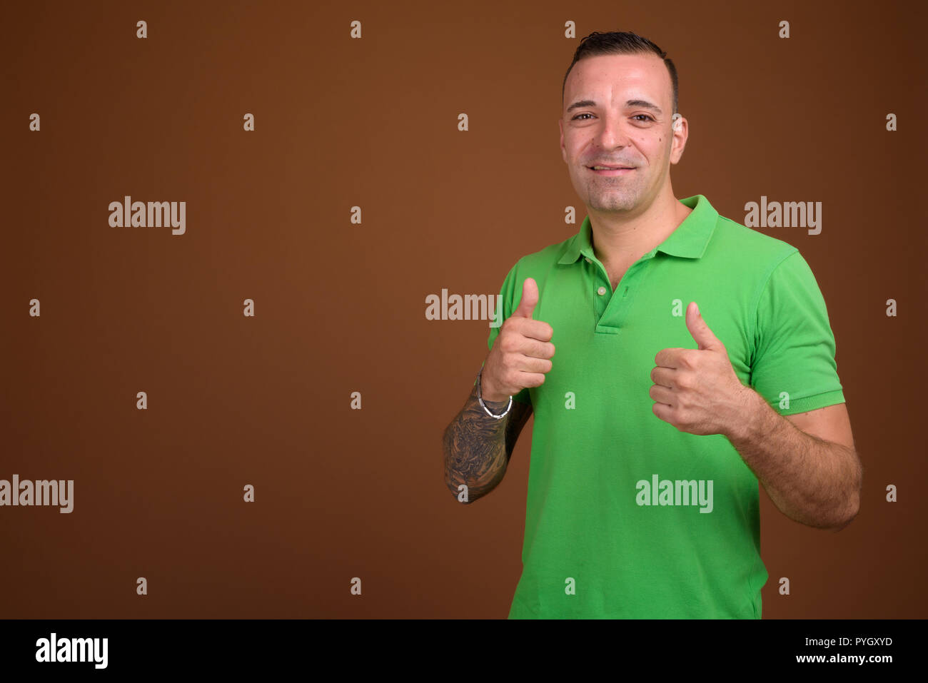 Mann, grünes T-Shirt gegen die braunen Hintergrund Stockfoto