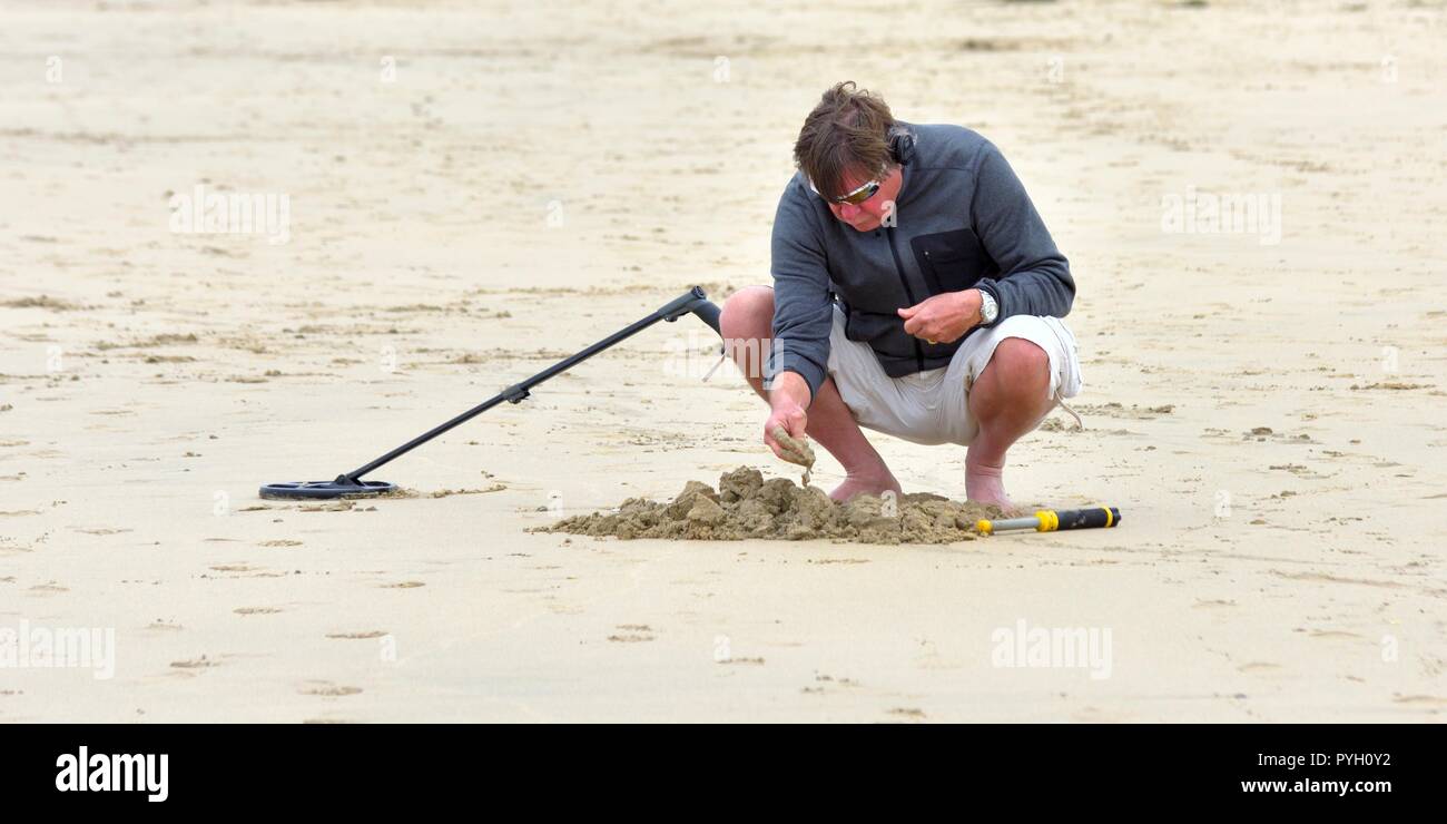 Ein Mann mit einem Metalldetektor auf einer britischen Strand Stockfoto