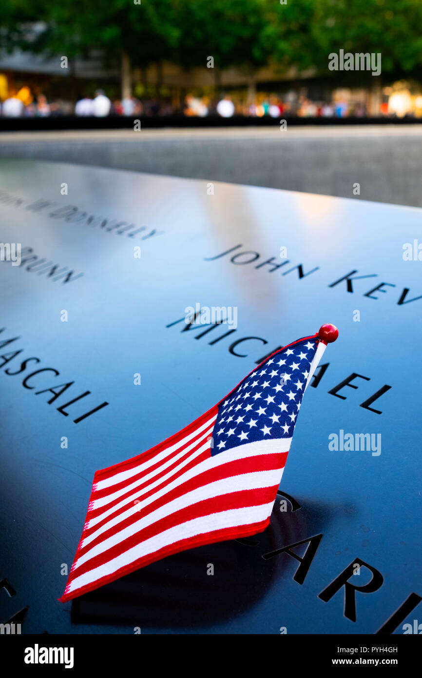 Die Namen einiger der Opfer durch die amerikanische Flagge markiert auf der 9/11-World Trade Center Memorial Brunnen in Lower Manhattan, New York City Stockfoto
