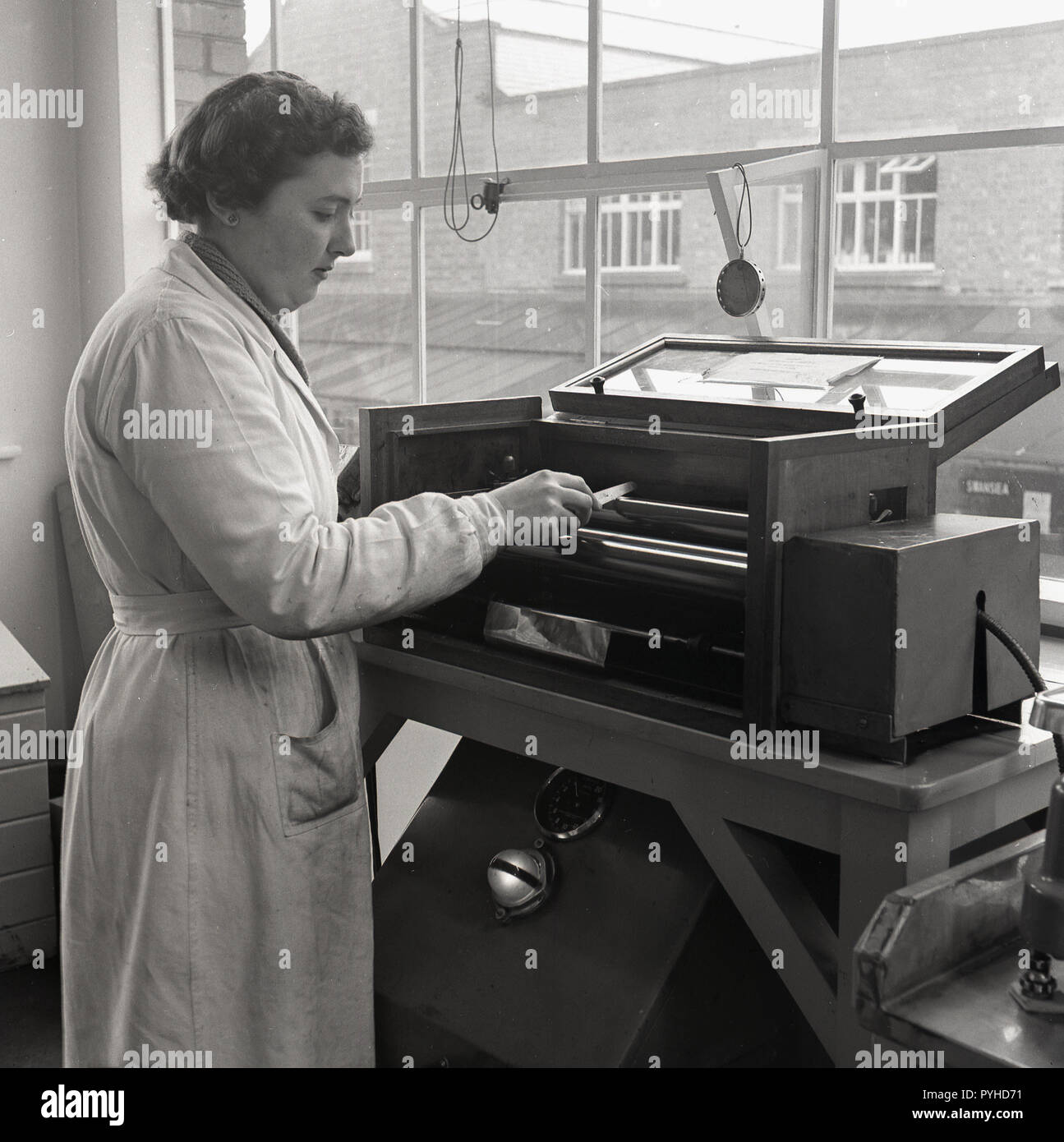 1950, historische, Lackherstellung, einer Technikerin im weißen Mantel mit einem Prüfgerät Farbenfabrik in einem Labor für die Untersuchung der verschiedenen mixages von Harzen, Pigmenten und Additiven in der Herstellung England Großbritannien eingesetzt. Stockfoto
