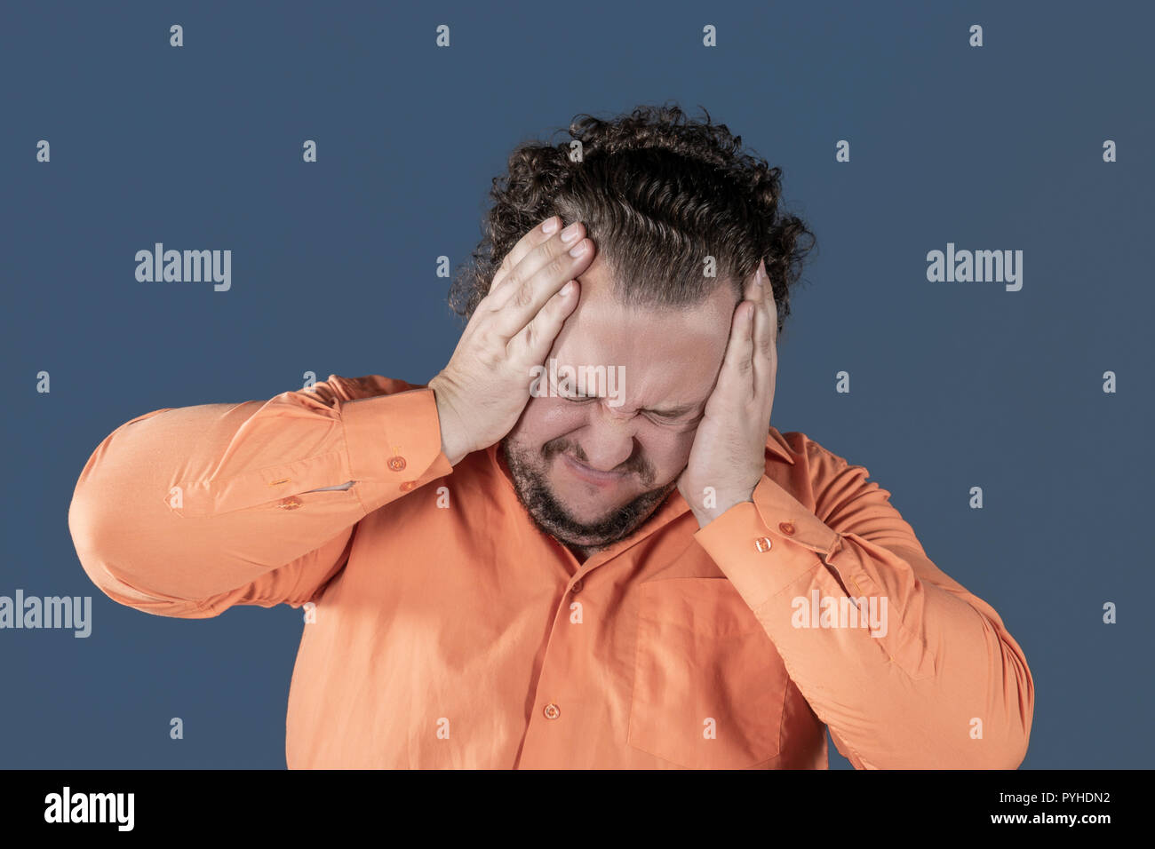 Ein fetter Mann hat hohen Blutdruck und Kopfschmerzen. Übergewicht und gesundheitliche Probleme Stockfoto