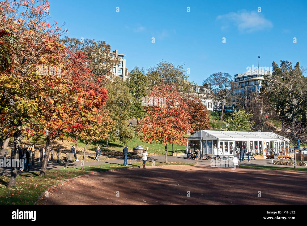 Bäume mit Farben des Herbstes in West Princes Street Gardens Edinburgh Schottland Großbritannien mit Cafe rechts Stockfoto