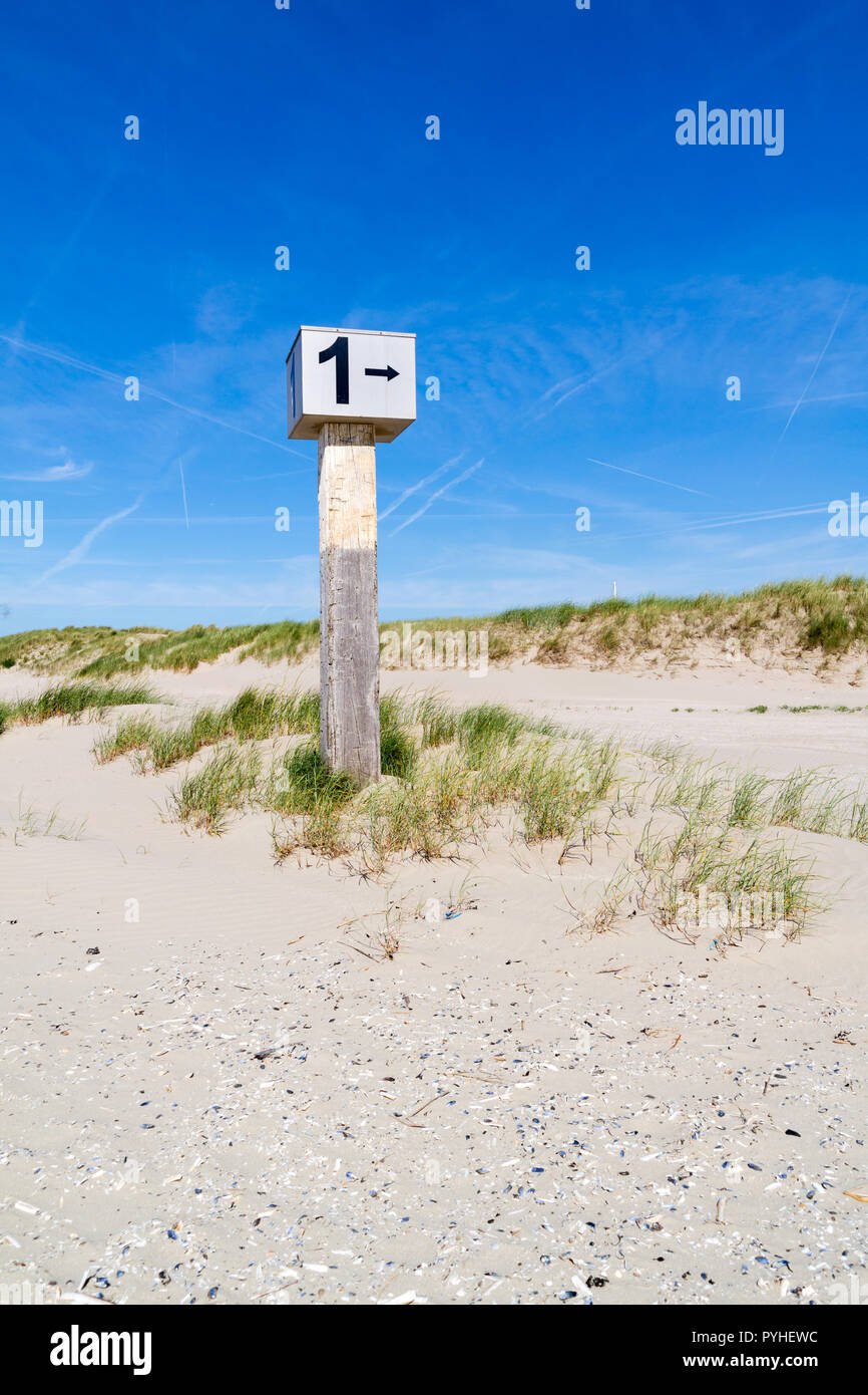 Markierten Strand Pole mit der Nummer 1 in Sand auf der Düne mit Gras auf marram Kennemerstrand Strand in IJmuiden, Noord-Holland, Niederlande Stockfoto