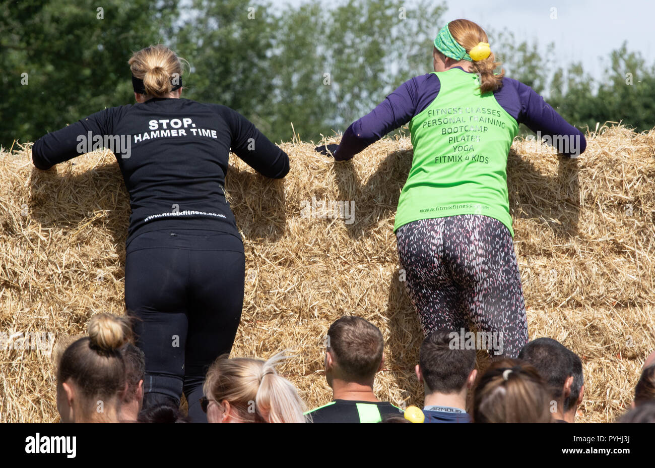 Zwei Frauen steigen ein strohballen Wand Stockfoto