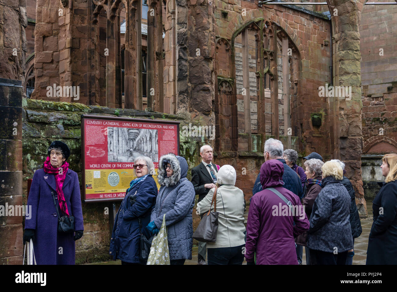 Eine Gruppe von Senioren, die Mitglieder der Universität des dritten Alters, auf einer geführten Tour von Coventry Cathedral, West Midlands, Großbritannien Stockfoto