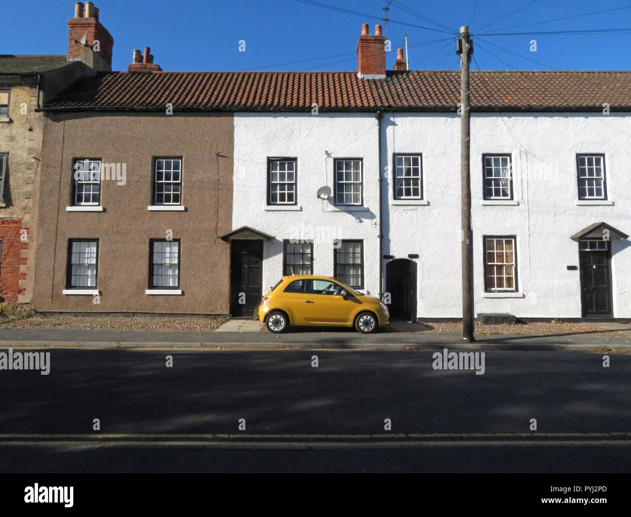 Die kleinen gelben Fiat Auto außerhalb ein Reihenhaus in Bawtry South Yorkshire England geparkt Stockfoto