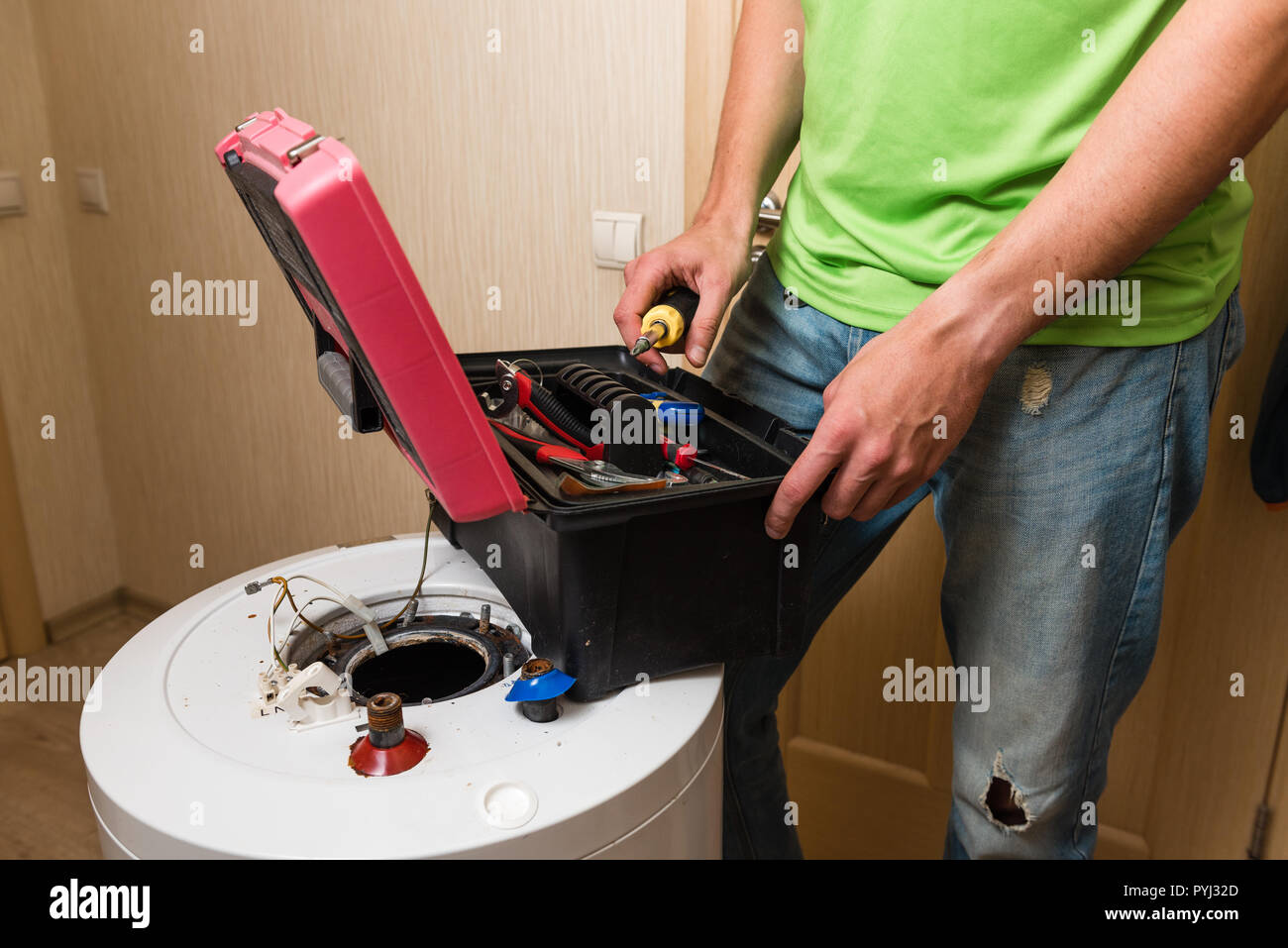 Männliche Klempner perair alter Kessel mit Schraubendreher innen Stockfoto