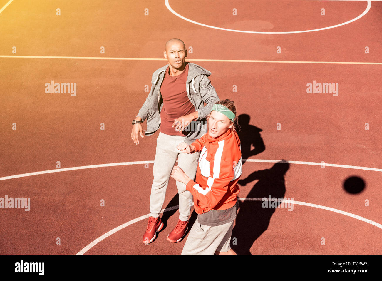 Schöne sportliche junge Männer, die gemeinsam spielen Basketball Stockfoto