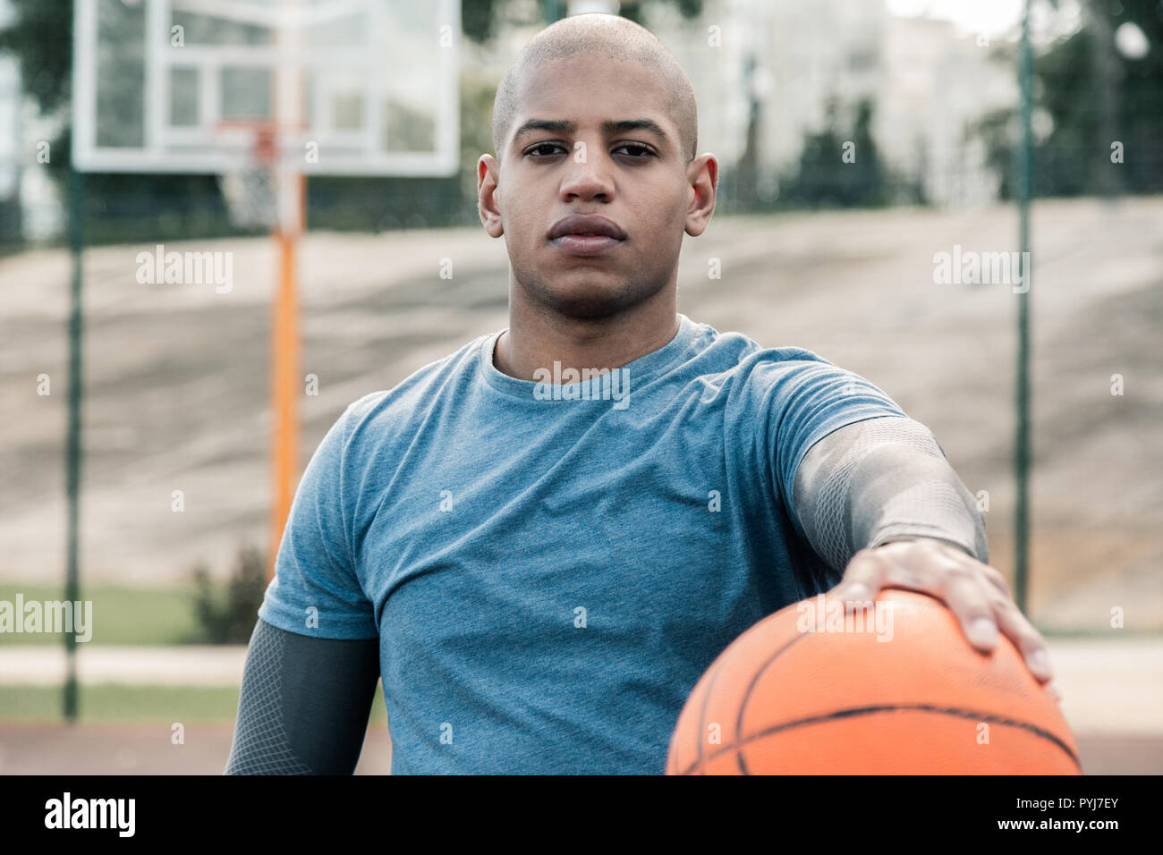 Angenehmer junger Mann training Basketball zu spielen Stockfoto