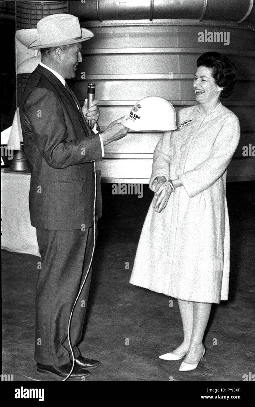 Marshall Space Flight Center Direktor Dr. Wernher von Braun präsentiert Lady Bird Johnson mit einem eingeschriebenen Hard hat während der ersten Dame des 24. März 1964 besuchen. Stockfoto