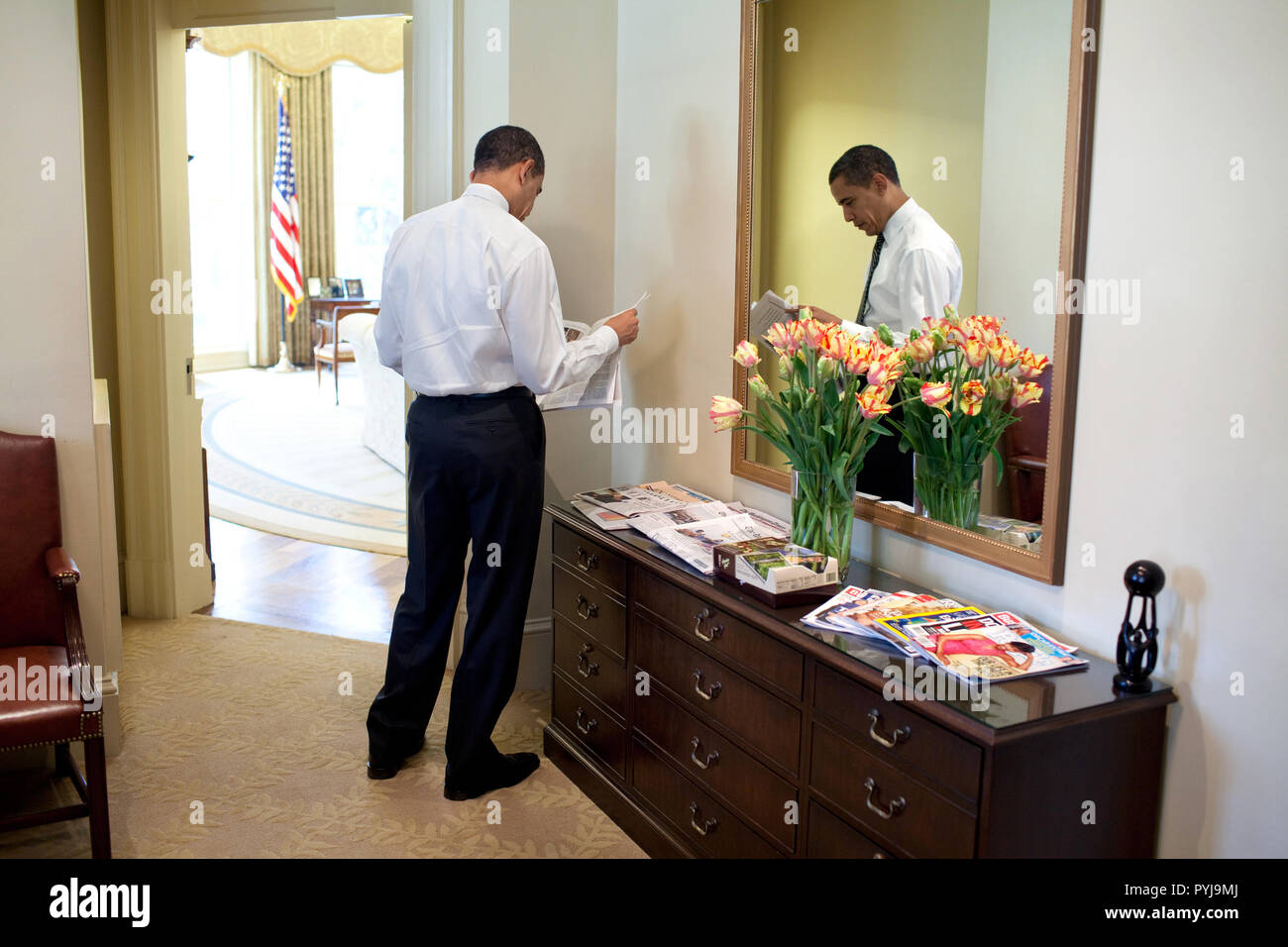 Präsident Barack Obama liest die Zeitung in der äußeren Oval Office 3/5/09. Stockfoto