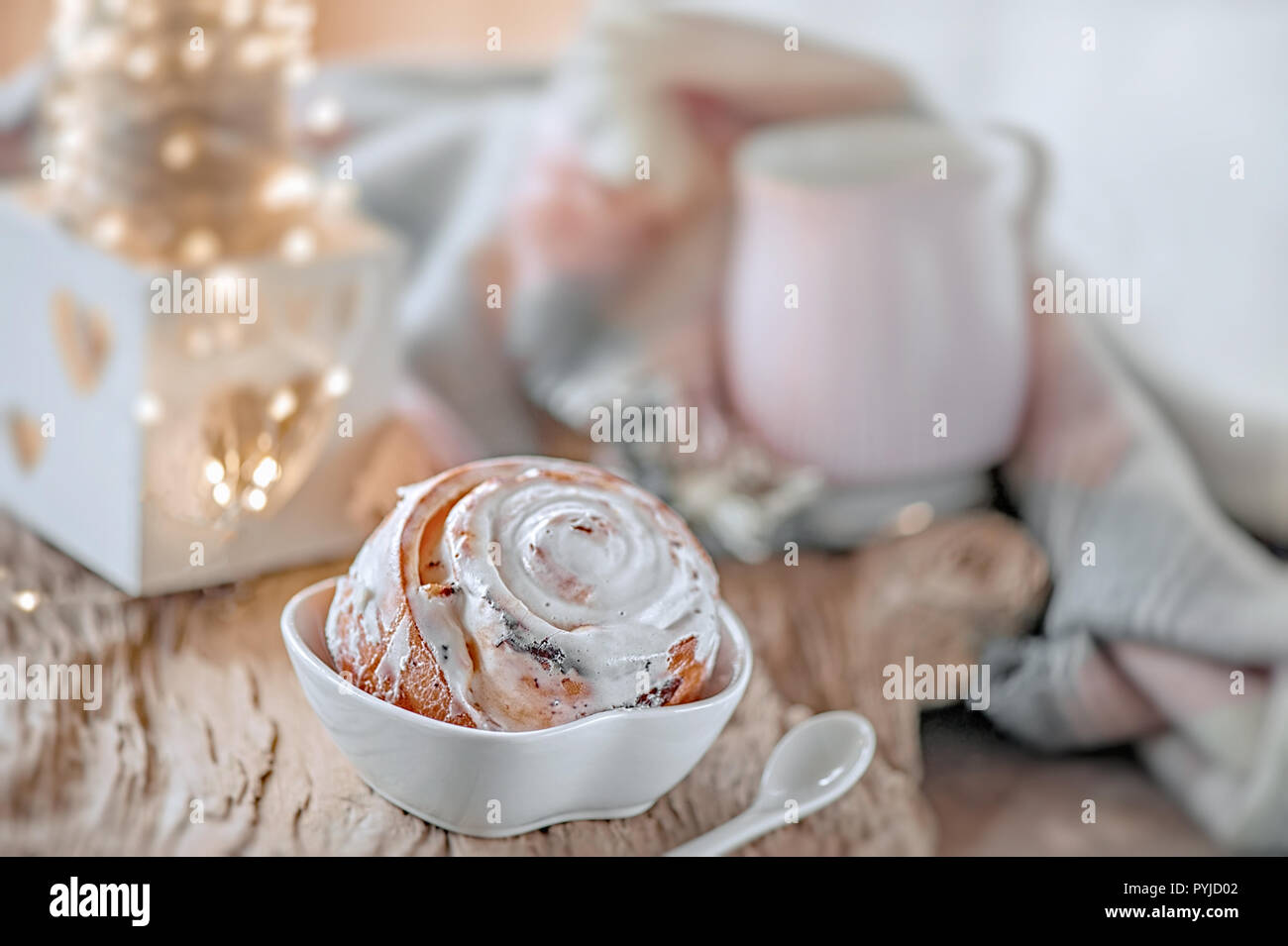 Leckere hausgemachte süße Brötchen mit Zimt und Puderzucker Weihnachten im alten Holztisch. Traditionelle schwedische Gebäck, kanelbullar. Stockfoto