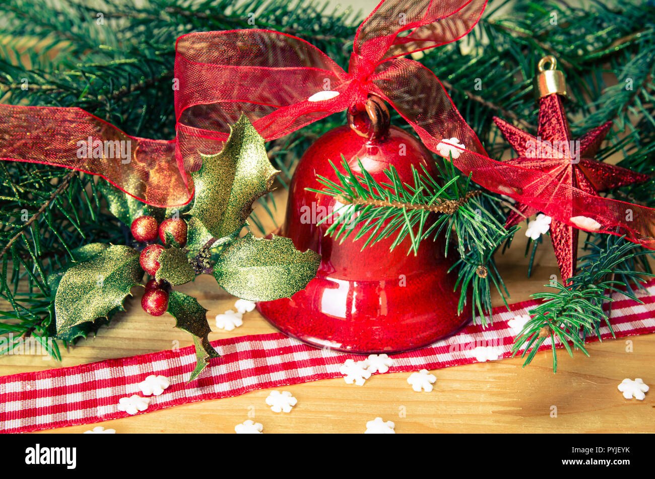 Weihnachtsdekoration mit roten Jingle Bell, Holly und grüne Nadel Zweig Stockfoto