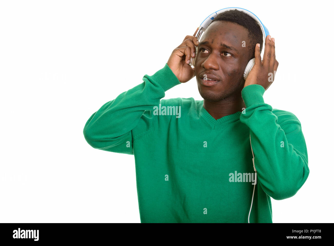 Afrikanischer Mann Musik hören mit Kopfhörern beim Denken Stockfoto