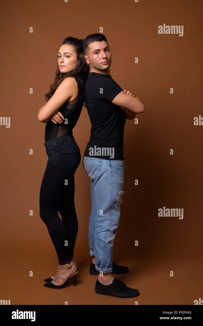 Junges Paar zusammen und in der Liebe gegen braunen Hintergrund Stockfoto