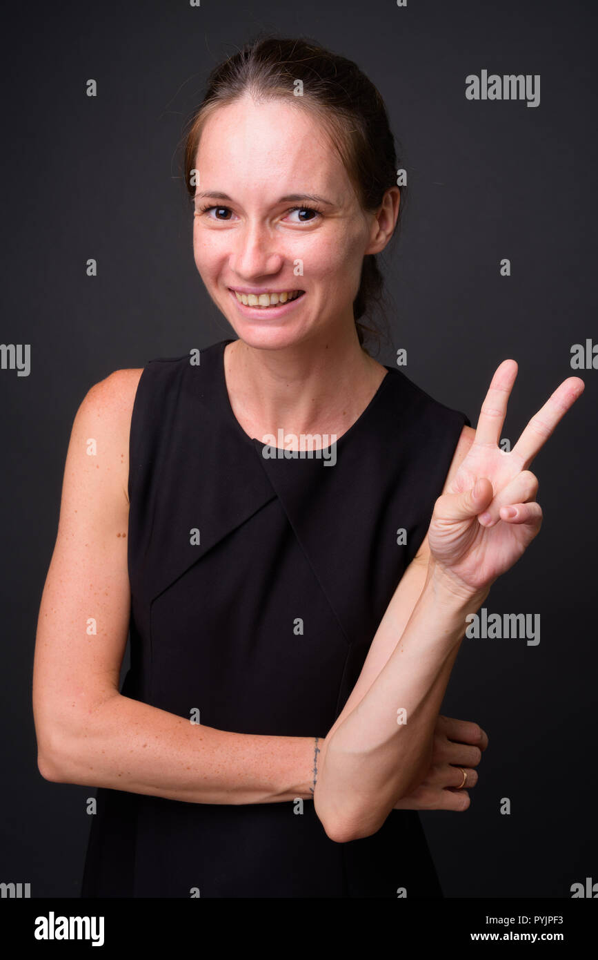 Studio schoss der schönen Frau gegen grauer Hintergrund Stockfoto