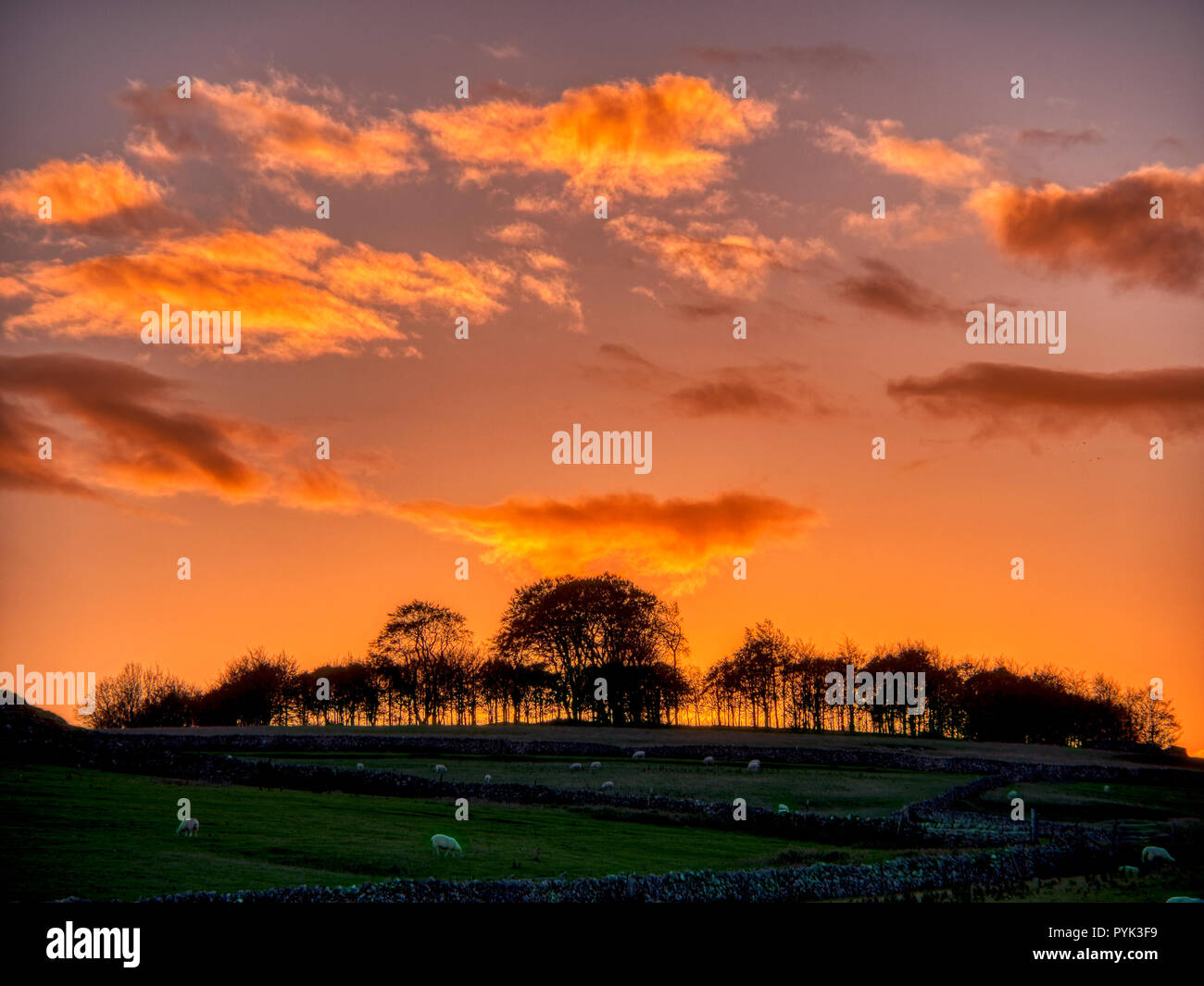 Harborough Felsen, Peak District, UK. 28 Okt, 2018. Wetter Großbritannien: Firey Sonnenuntergang über Minninglow hill Historische England Monument mit einem chambered Grab & zwei Schüssel barrows Peak District National Park, UK Credit: Doug Blane/Alamy leben Nachrichten Stockfoto