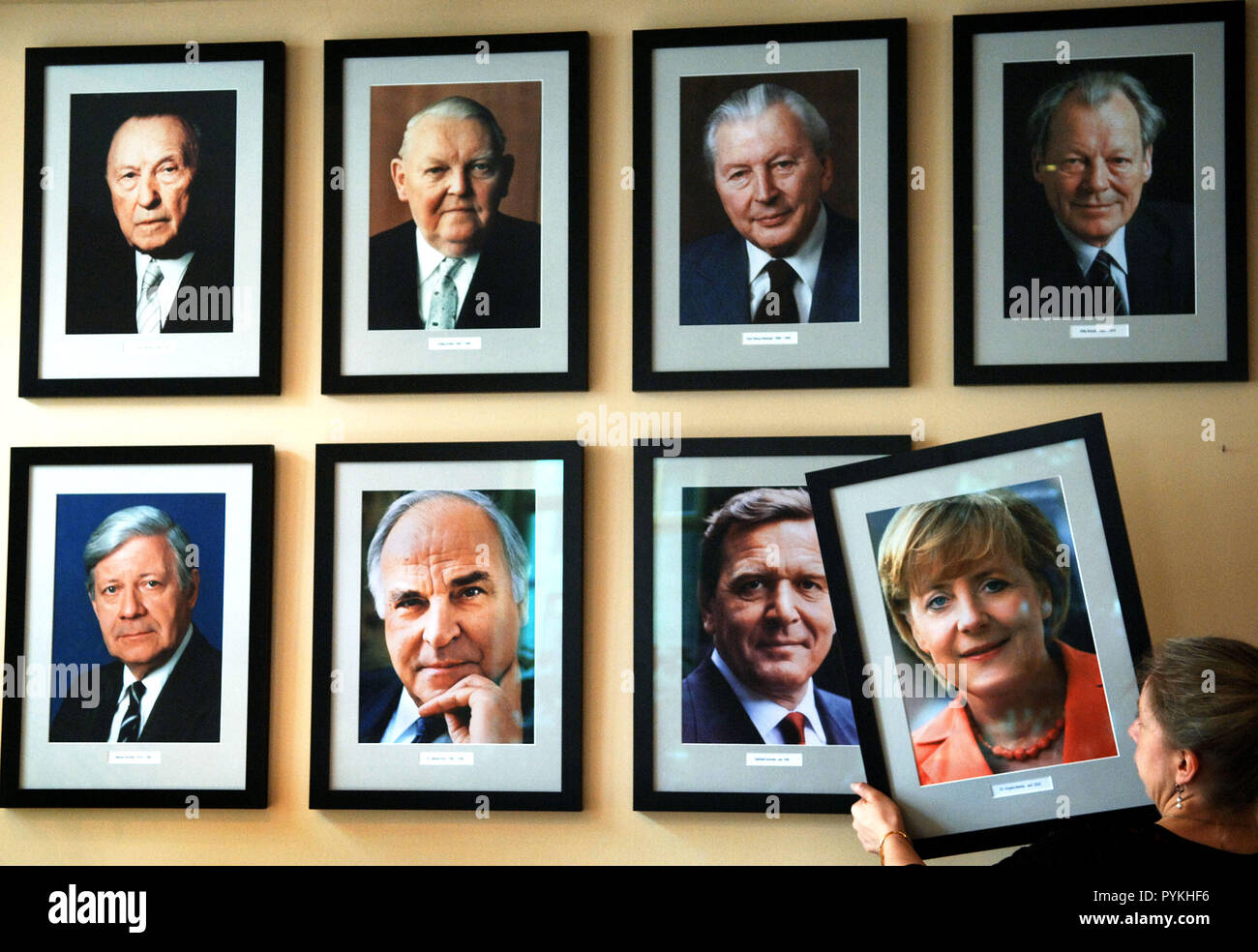Das Foto der neuen Bundeskanzlerin Angela Merkel wird am Mittwoch Hung (23.11.2005) im Restaurant "KanzlerEck" in Berlin Neben den Porträts der ehemaligen deutschen Kanzler - von links nach rechts oben: Konrad Adenauer (CDU), Ludwig Erhard (CDU), Georg Kiesinger (CDU), Willy Brandt (SPD), von links nach rechts unten: Helmut Schmidt (SPD), Helmut Kohl (CDU), Gerhard Schröder (SPD). Merkel hatte der Tag gewählt, bevor sie durch den Bundestag für den ersten deutschen Bundeskanzler. Foto: Jens Buttner dpa/lbn (c) dpa-Bericht | Verwendung weltweit Stockfoto