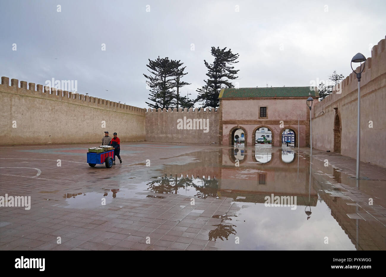 Mann mit wheel Barrow vor der Bab El Mechouar auf Place Moulay Hassan in Essaouira, Marokko, Afrika Stockfoto