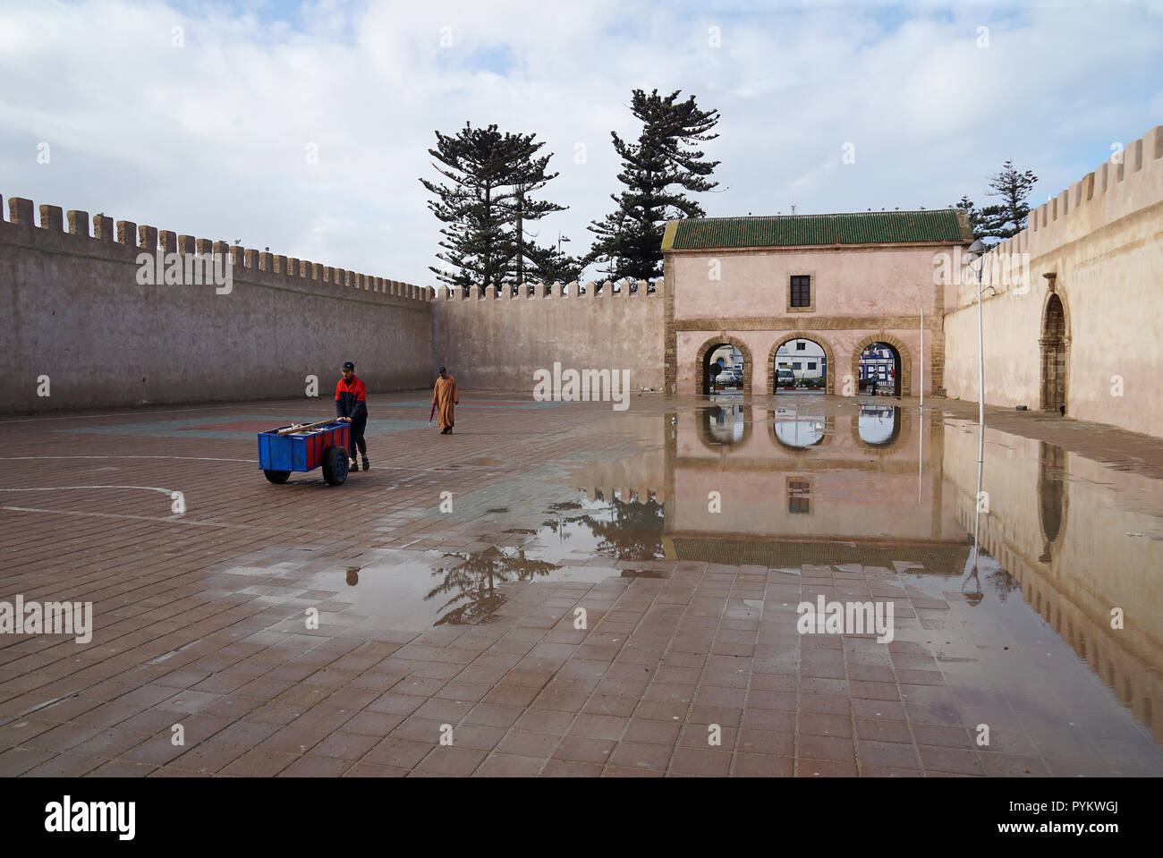 Mann mit wheel Barrow vor der Bab El Mechouar auf Place Moulay Hassan in Essaouira, Marokko, Afrika Stockfoto