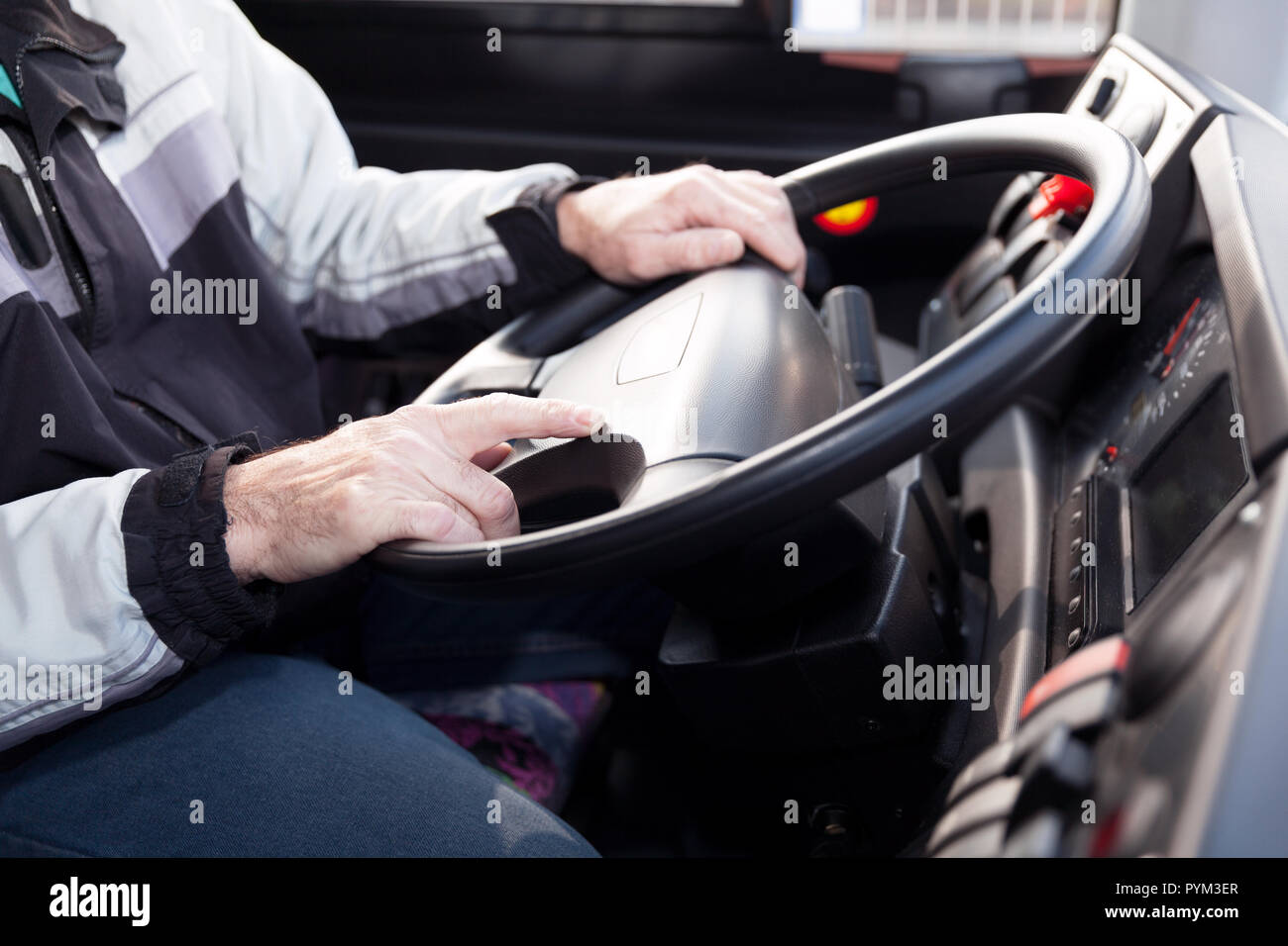 Lkw-Fahrer, die Hände am Lenkrad und Sitzen im Fahrzeug. Stockfoto