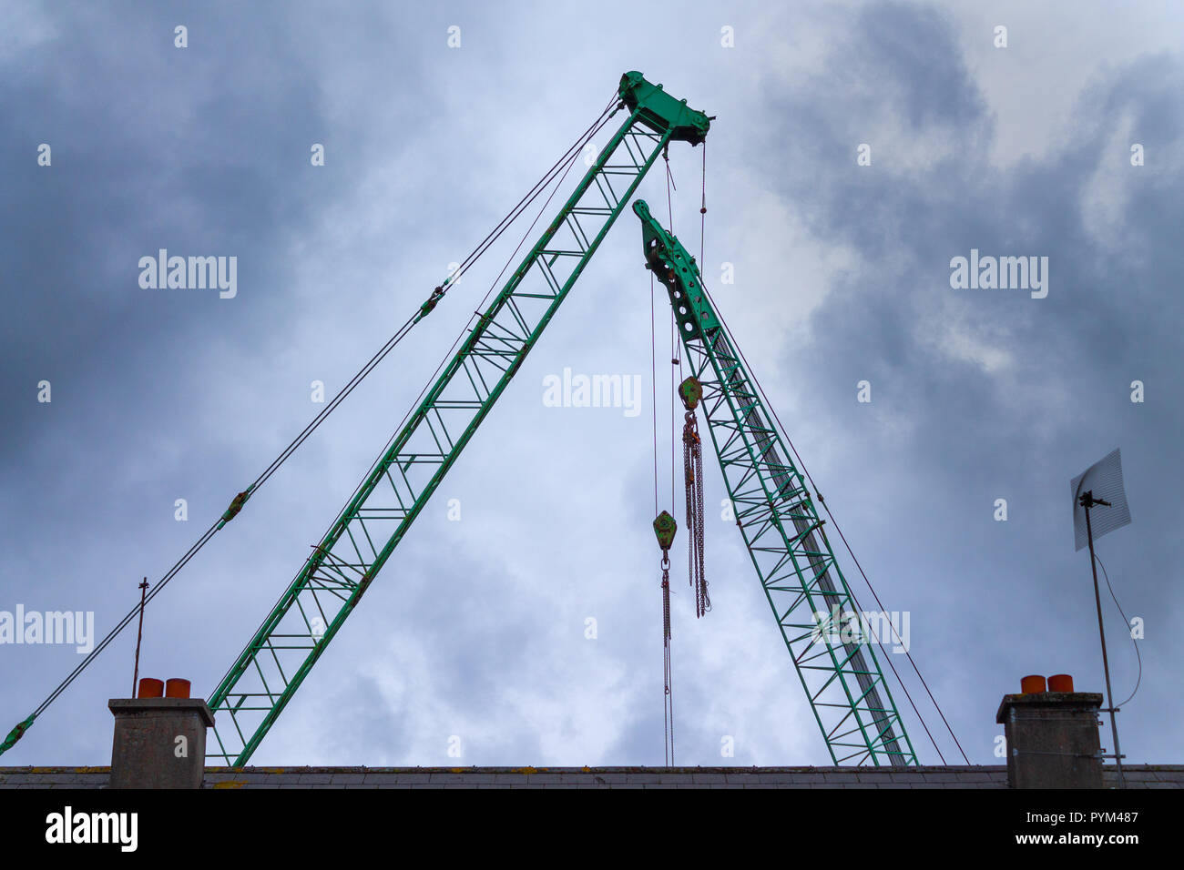 Kran Arme oder Ausleger oder Kran Kräne vor grauem stürmischen Himmel Silhouette Stockfoto