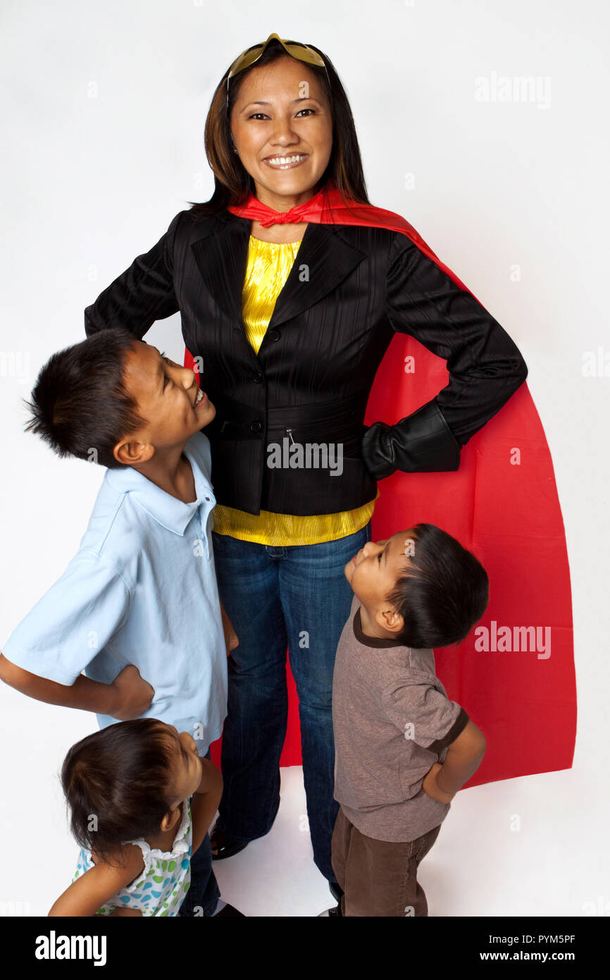 Super Hero Mama mit ihren Kindern halten Lebensmittel. Stockfoto