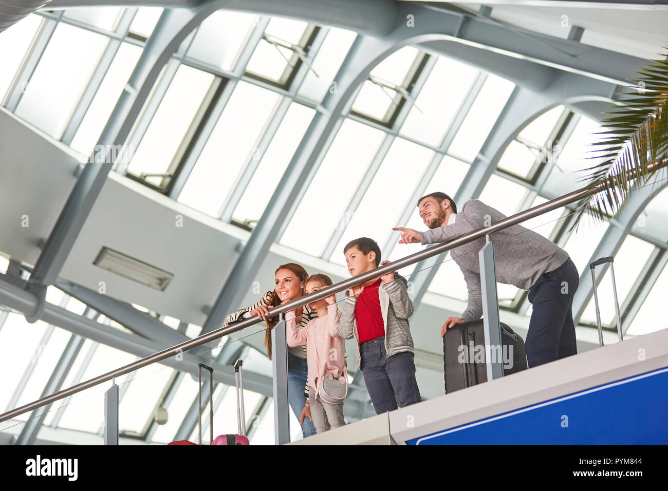 Familie mit zwei Kindern auf der Galerie im Flughafengebäude ist Fliegen im Urlaub Stockfoto
