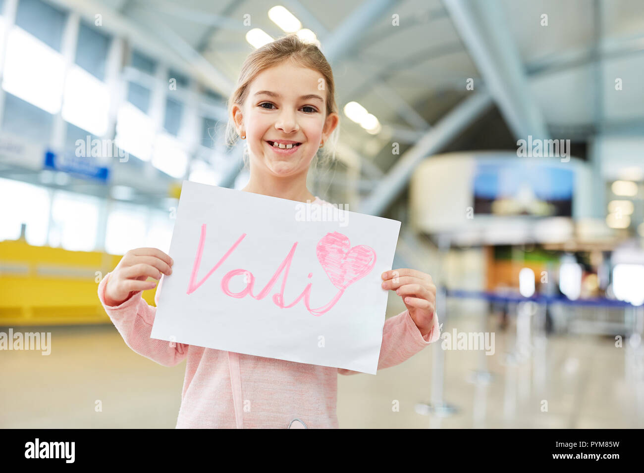 Happy girl am Flughafen hält ein Schild in der Grußansage für Ihr Vati Stockfoto