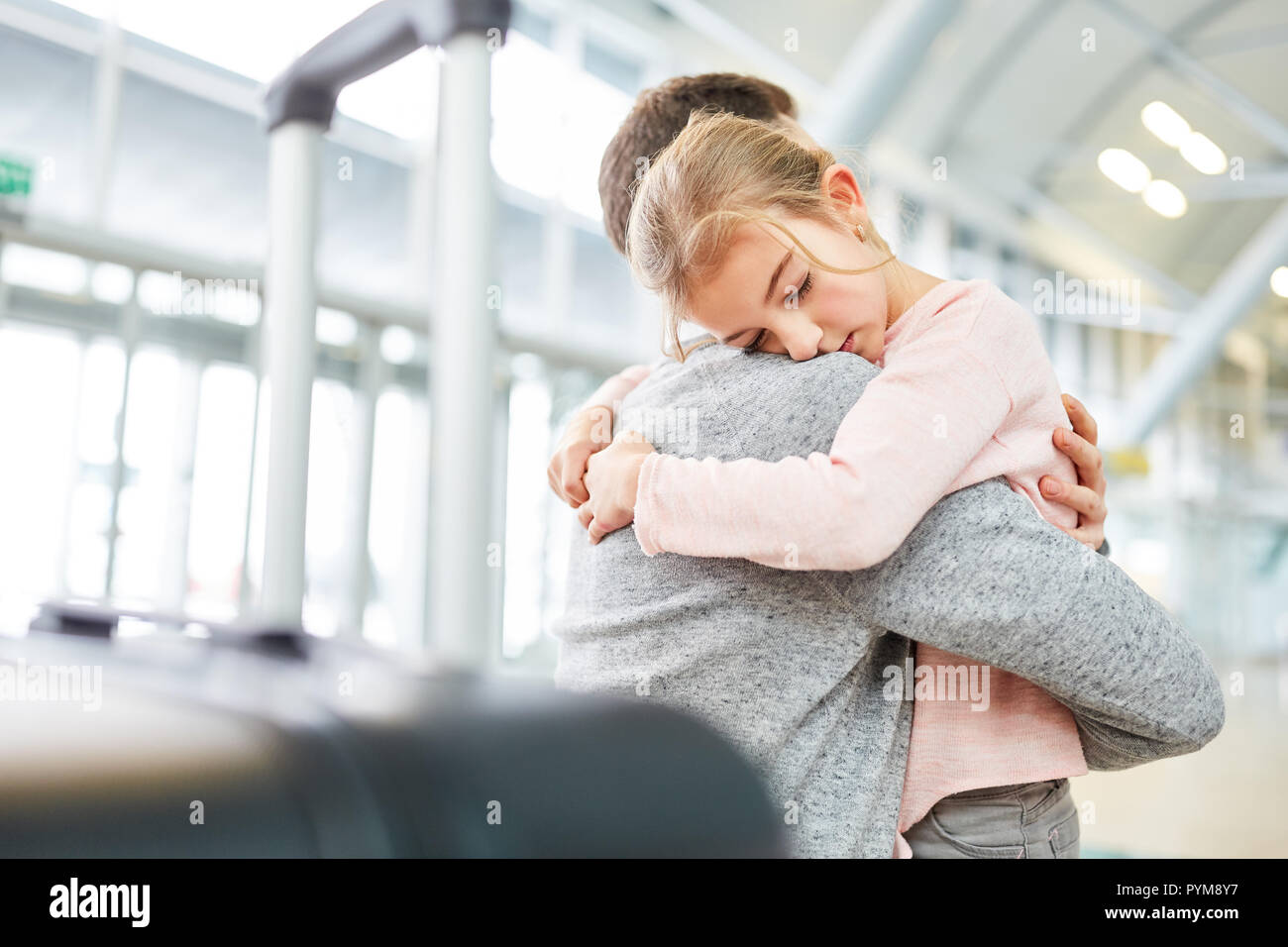 Vater und Tochter umarmen sich "auf Wiedersehen" oder bei der Ankunft am Flughafen Terminal Stockfoto