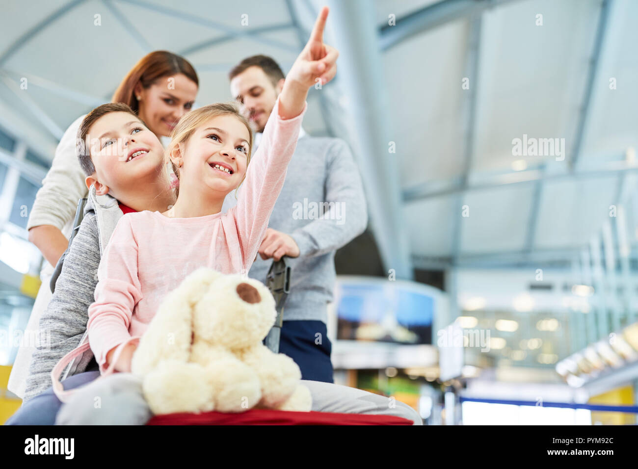 Glückliche Kinder und Eltern im Flughafenterminal sind glücklich und in den Urlaub fliegen Stockfoto