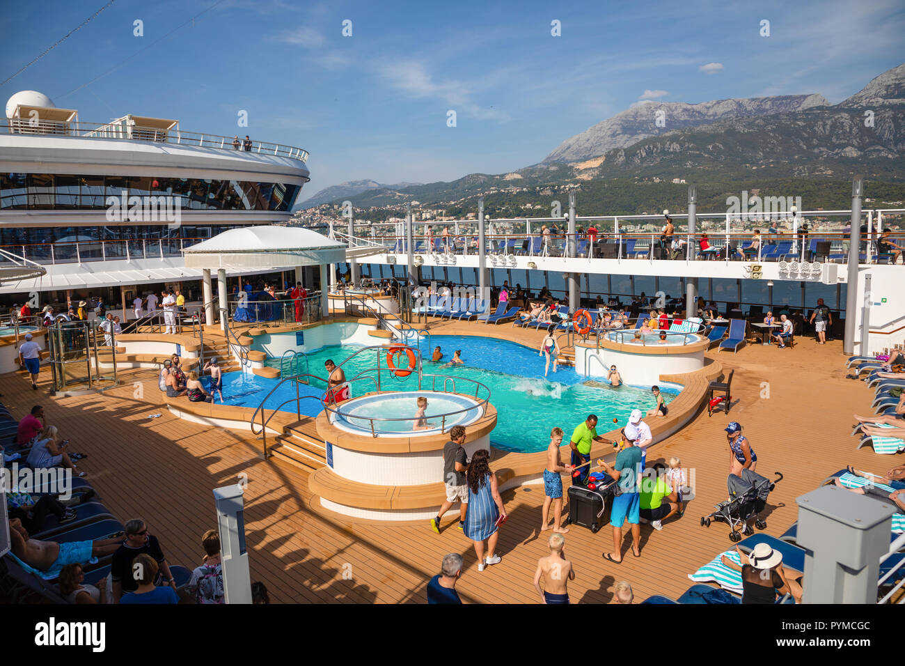 Mittelmeer, Montenegro - 15.10.2018: Touristen am Pool im Kreuzfahrtschiff Norwegian Star während einer Kreuzfahrt nach Griechenland entspannen Stockfoto