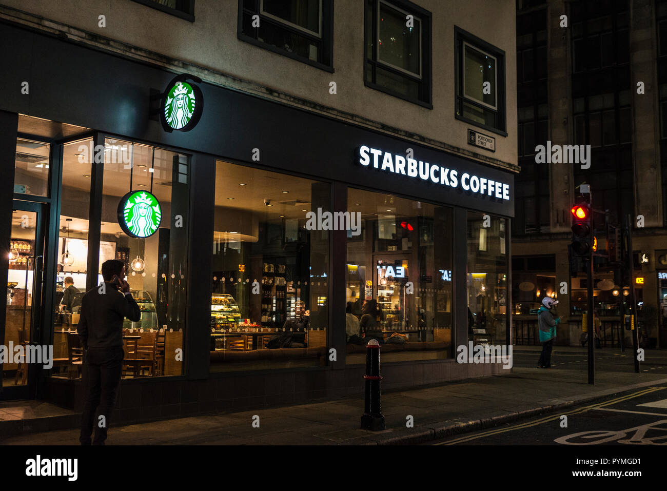 London, Großbritannien - 4. Januar 2018: Starbucks Kaffee mit mit einem Mann Anrufen per Handy in London, England, Vereinigtes Königreich Stockfoto
