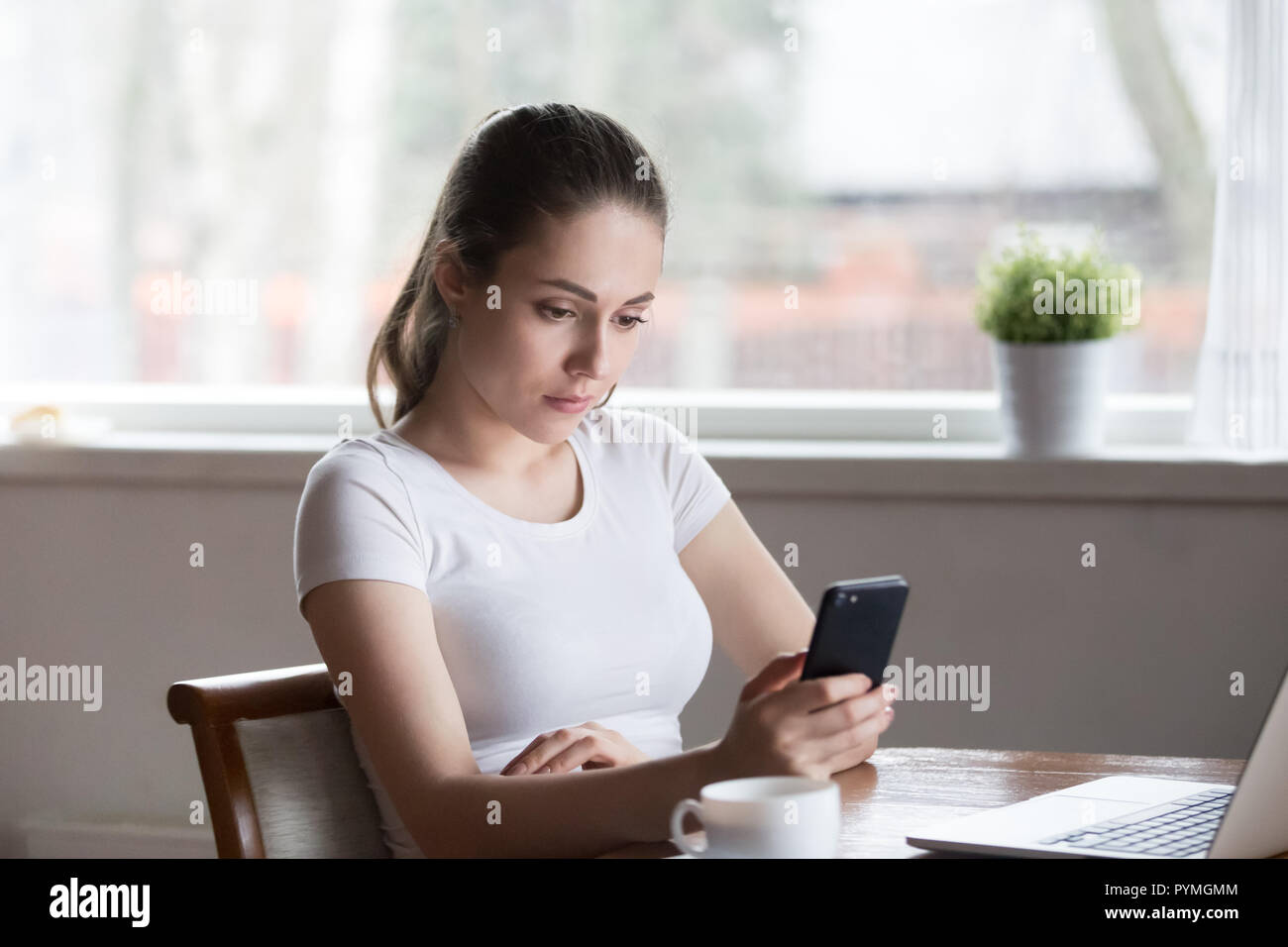 Nachdenklich ernsten Frau Holding am Bildschirm des Smartphones auf der Suche Stockfoto