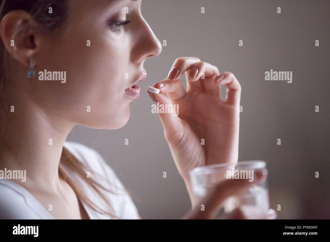Close up Frau hält Glas Wasser und Pille Stockfoto