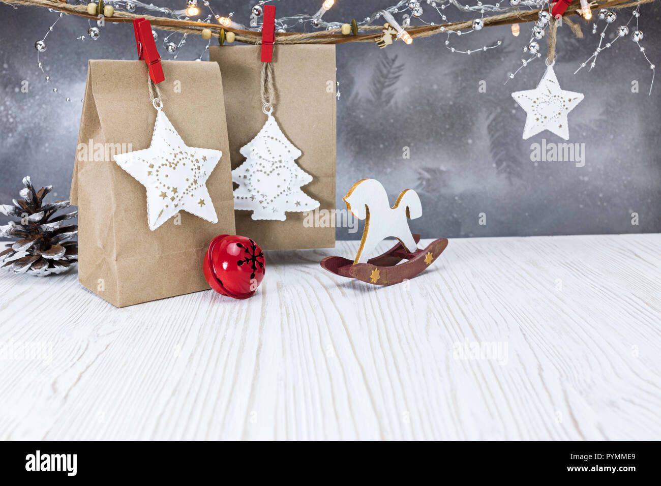 Weihnachten handgefertigte Geschenkbeutel, sanftes Licht Girlanden und Dekorationen gegen Silber Hintergrund hängenden Stockfoto