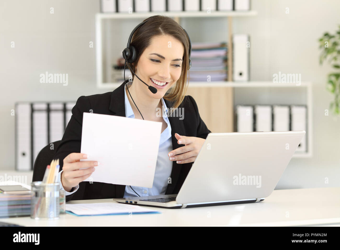 Telemarketer an einem Anruf Beratung online Informationen in einem Laptop im Büro Stockfoto