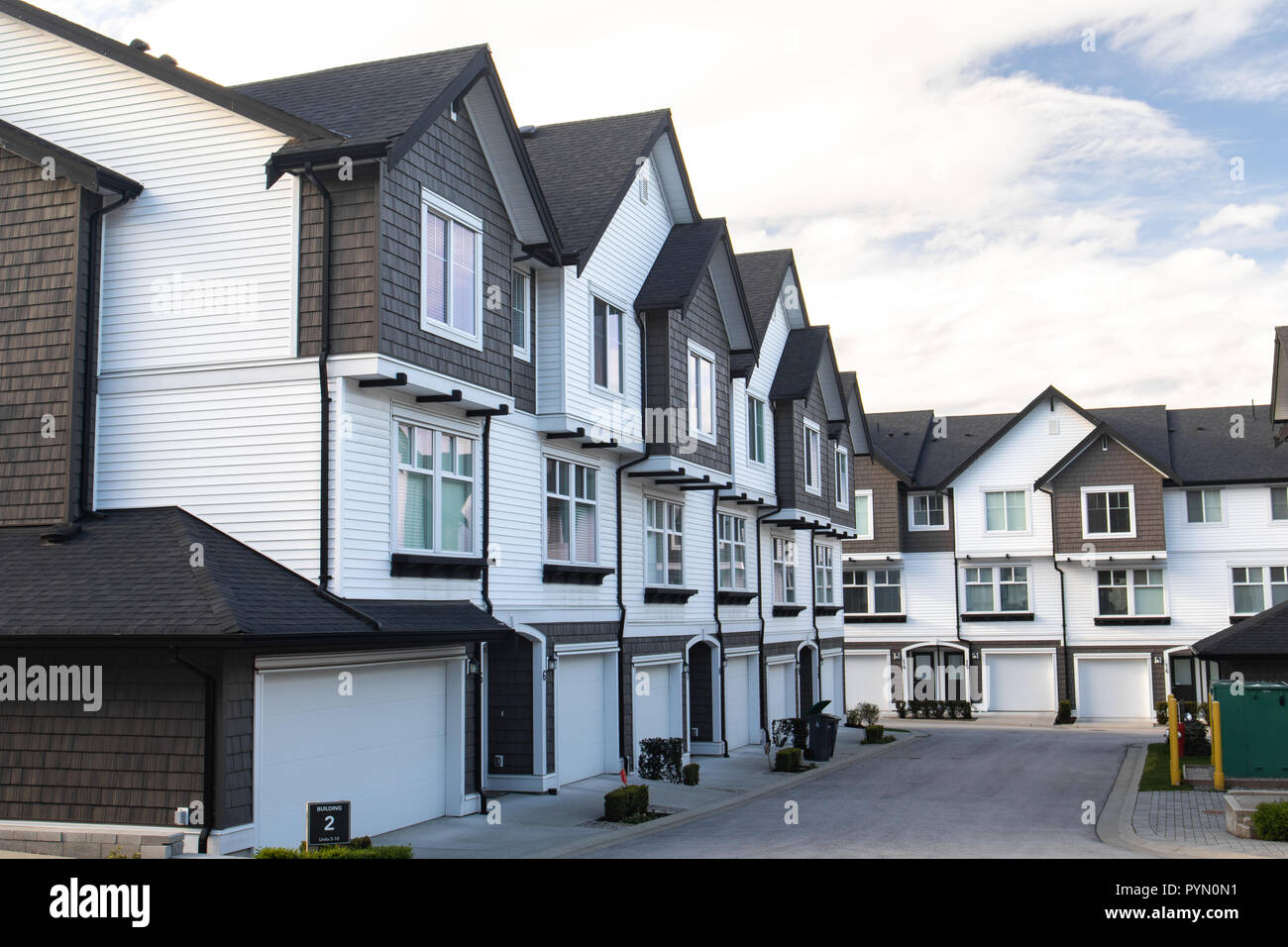 Neue Stadthäuser mit konkreten Bürgersteig vor. Vorderseite von Stadthäusern an einem sonnigen Tag in Kanada. Stockfoto