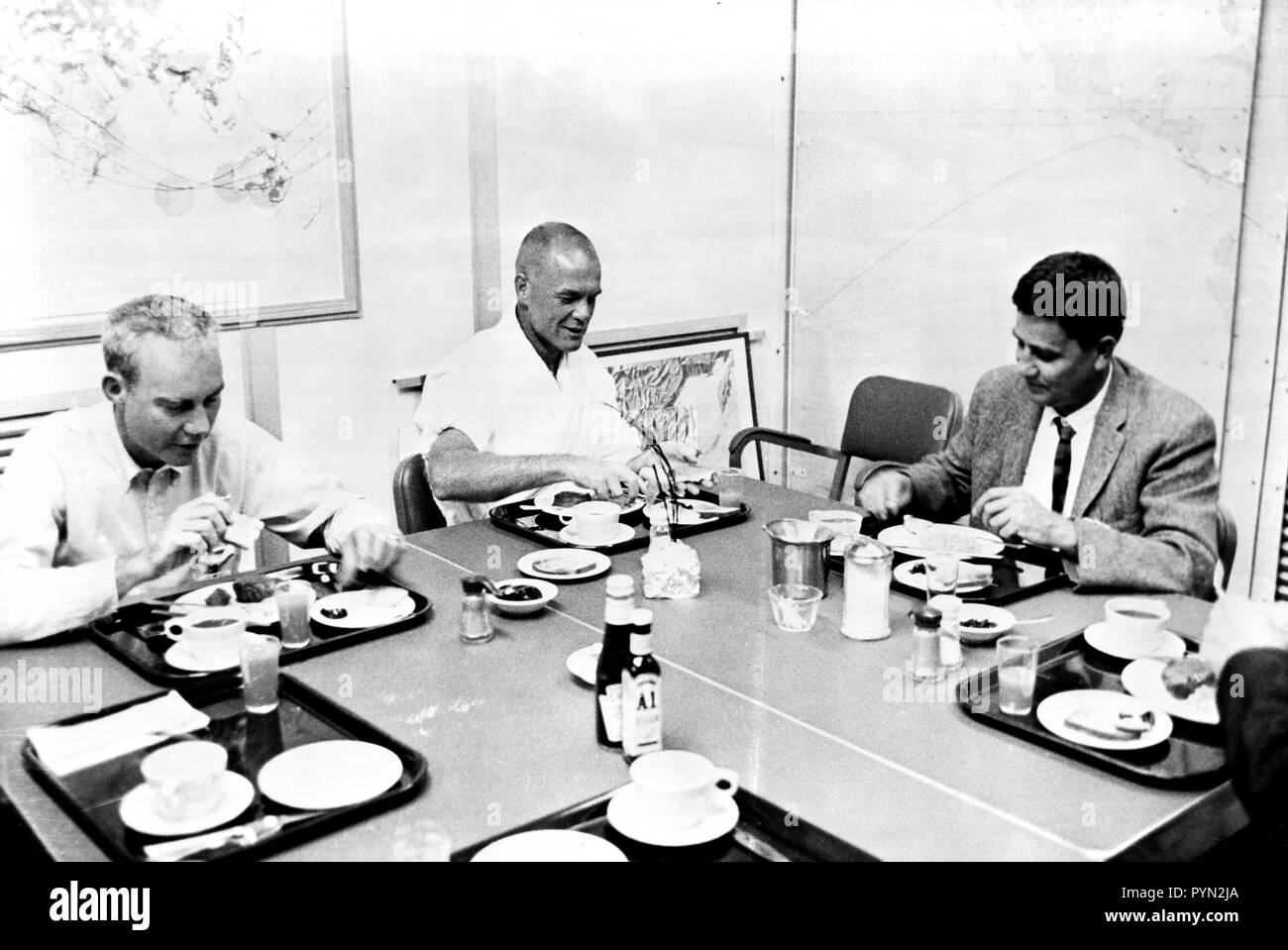 (20 Februar 1962) - - - Astronaut John Glenn Jr. (Mitte) isst Frühstück am Morgen der Produkteinführung seiner Mercury-Atlas 6 (MA-6) Raumfahrzeuge. Dr. William K. Douglas ist auf der rechten Seite. Stockfoto