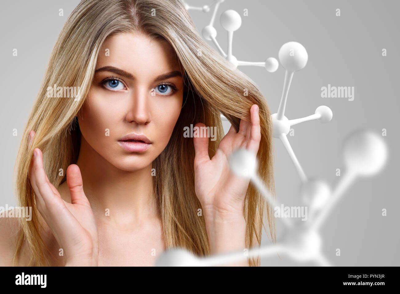 Junge blonde Frau in der Nähe von Big White Molekül Kette. Stockfoto