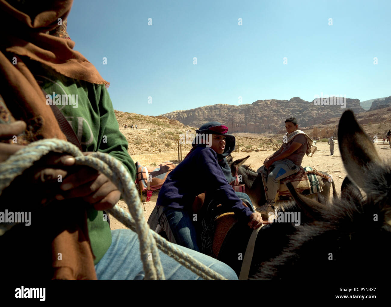 Bedouin Männer und Jungen neigen dazu, ihre Esel, Pferde und Kamele, Fahrten für Touristen in der Petra Archäologischen Park zu bieten, in Jordanien am 29. Oktober 2018 Stockfoto