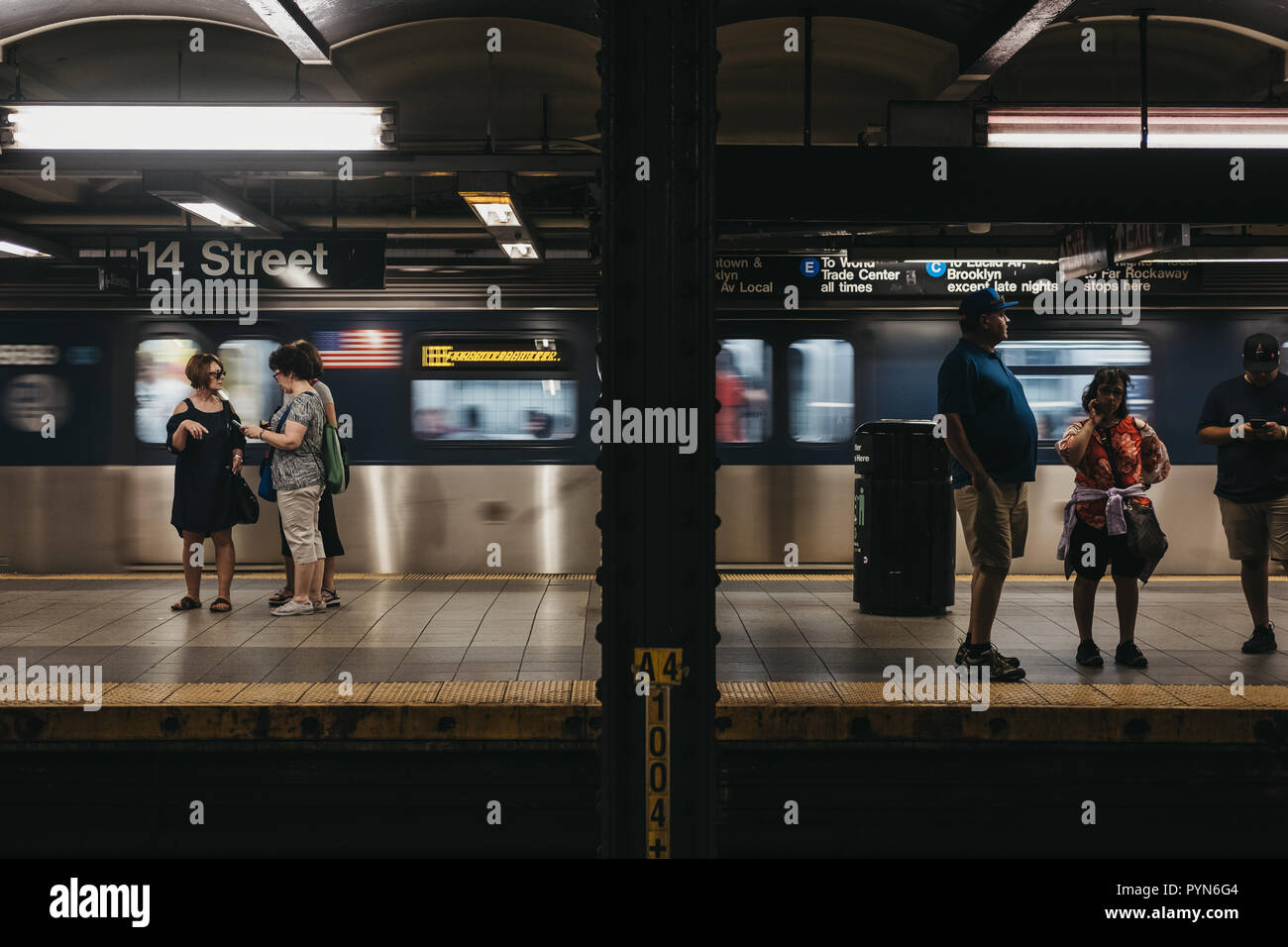 New York, USA - Juni 2, 2018: die Menschen stehen auf der 14. Straße U-Bahn in New York, fahrenden Zug auf dem Hintergrund. New York City U-Bahn ist eine der t Stockfoto