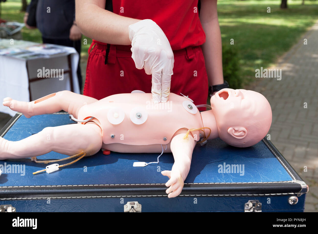 Demonstration der kardiopulmonalen Reanimation auf einer Hlw-Baby dummy während der Schulung in erster Hilfe. Stockfoto