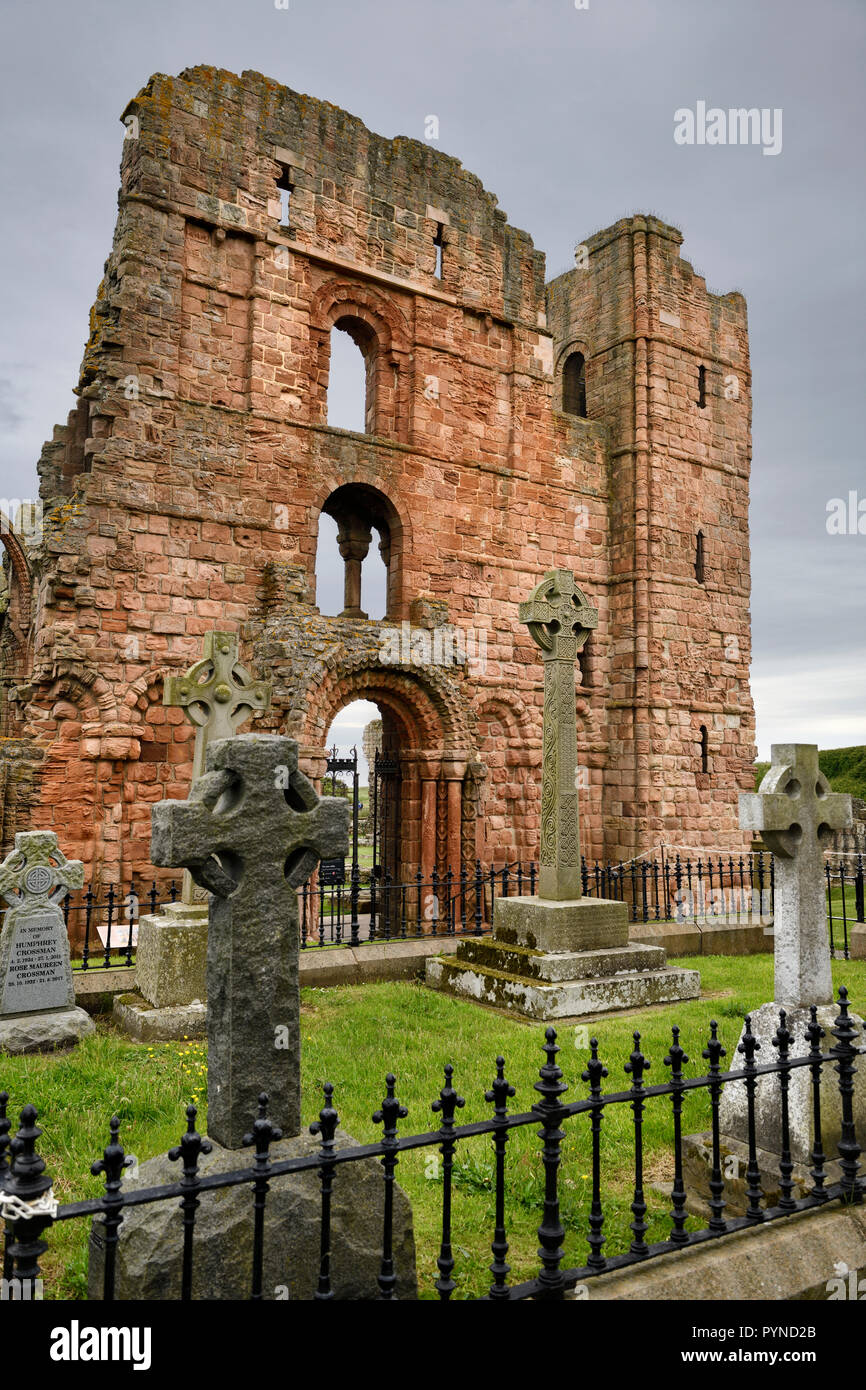 Red Stone Front von Lindisfarne Kirche Ruinen der mittelalterlichen Kirche mit Friedhof Grabsteine auf der heiligen Insel von Lindisfarne England Großbritannien Stockfoto