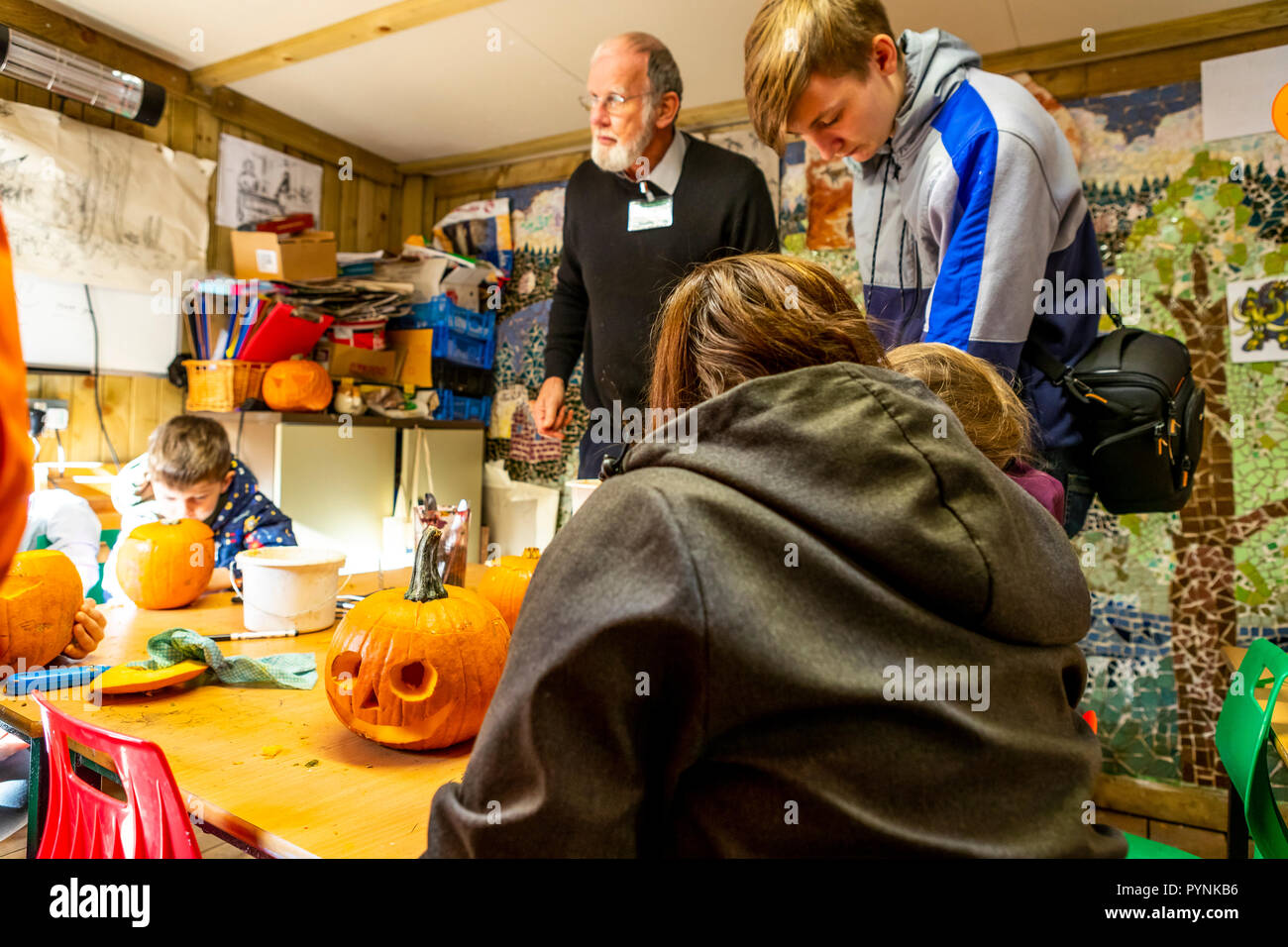 Kinder und Erwachsene Kürbis schnitzen. Kürbisfest, Dekan Heritage Center, Wald von Dean. Stockfoto