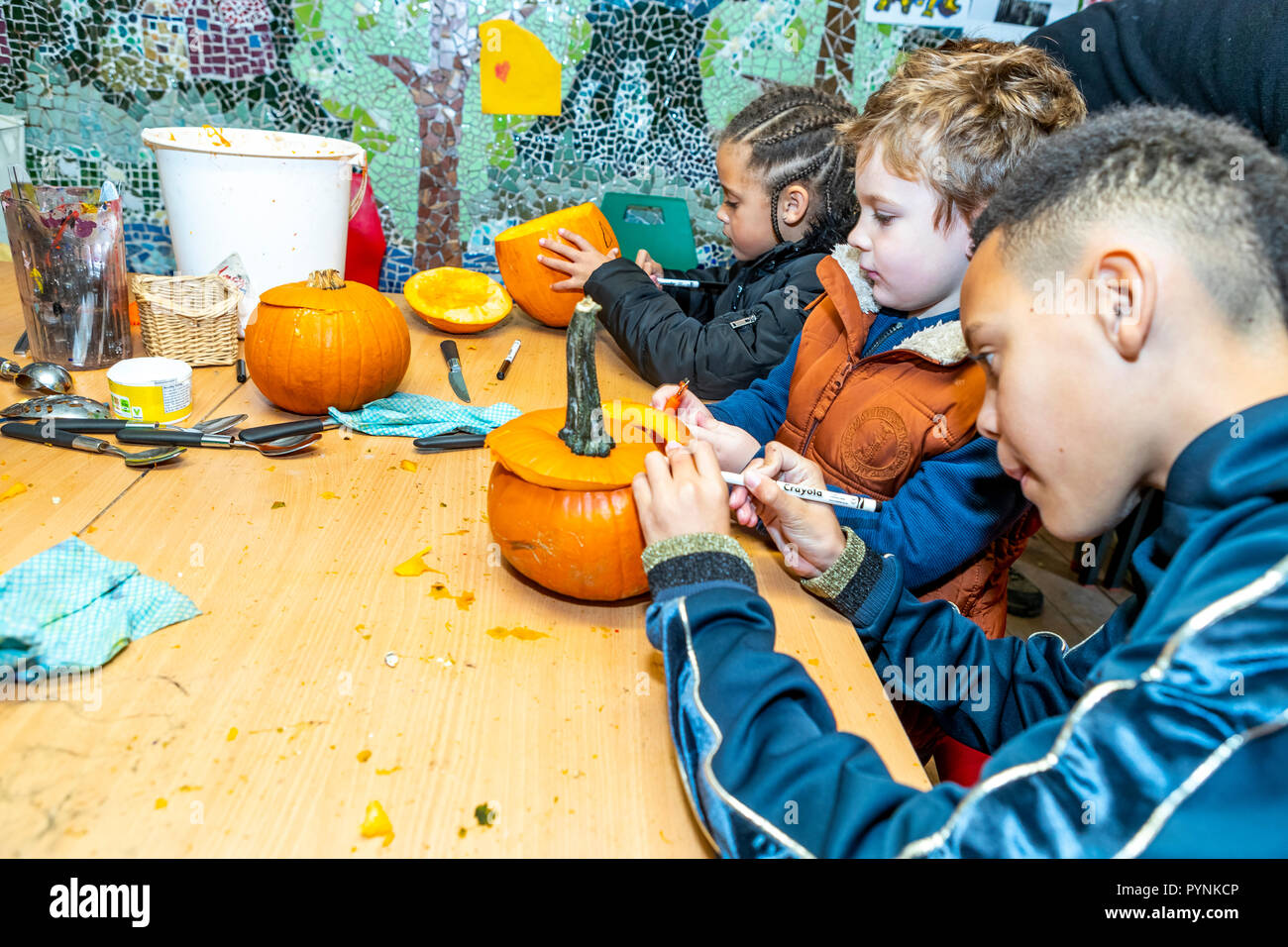 Kinder und Erwachsene Kürbis schnitzen. Kürbisfest, Dekan Heritage Center, Wald von Dean. Stockfoto