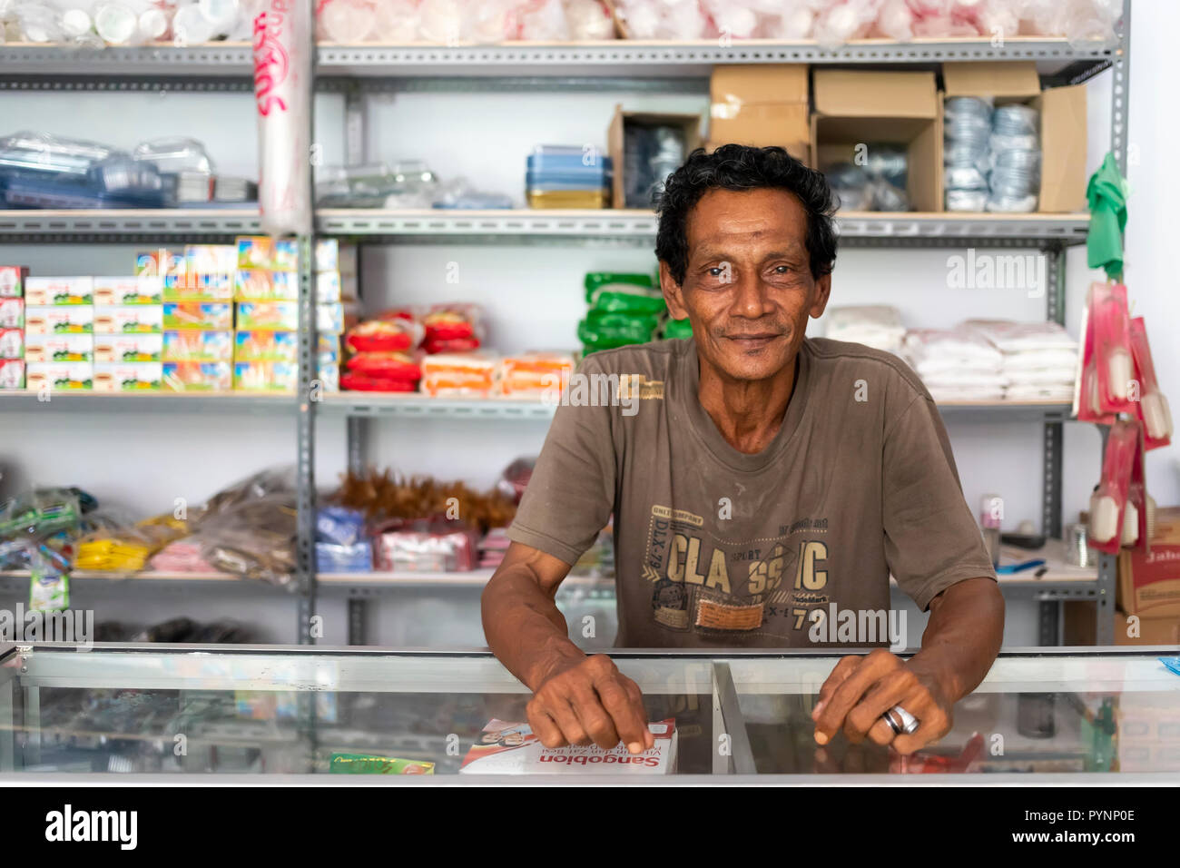 BANDA NEIRA, Sumatra, Indonesien, 19. Dezember 2017: Porträt einer fröhlichen lokalen Komfortable Shop Verkäufer in Banda Neira, Komodo, Indon Stockfoto